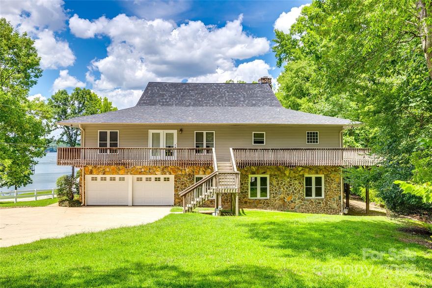 Welcome Home to Lake Life! This beautiful lakefront property sits on almost 2 acres and boasts a private dock capable of accommodating a lift, a lakeside gazebo, and is situated on a deep water cove, with depths up to 30 feet! The outdoor space is an entertainer's dream, featuring a large wraparound deck with stunning lake views. The interior offers an open floor plan, a large kitchen, a built-in bar, and a huge island. The upper level of this home features a primary suite and two additional bedrooms with full bathrooms. The main level offers another large bedroom, full bathroom, laundry room, and family room. Recent updates and upgrades include new electric blinds in the living room, a new roof in 2023, a new septic pump station and drain field in 2023, and a water filtration and softening system.