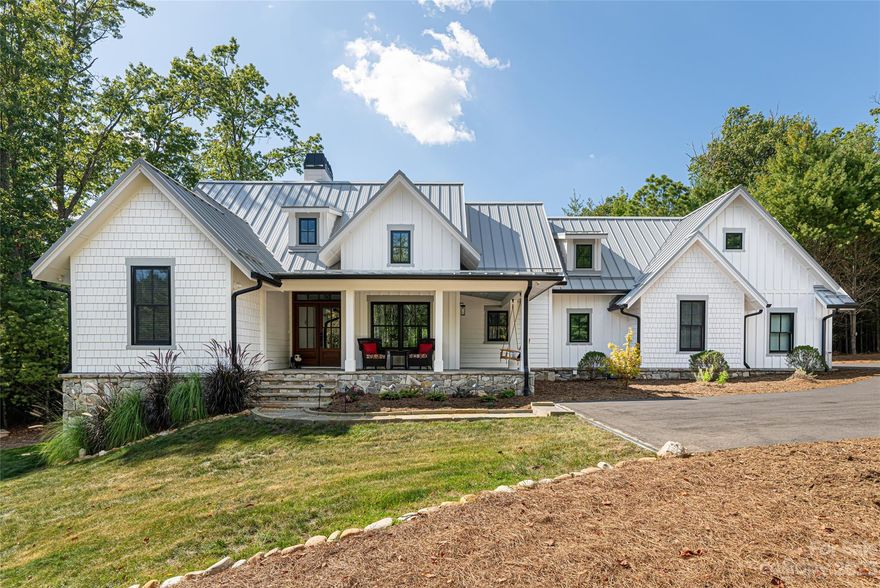 Within the Ramble gates lies a serene 4.8+-acre oasis. Here, a picturesque, custom white four-bedroom, 3.5-bath farmhouse graces an expansive landscape surrounded by lush greenery. The welcoming front porch opens to an easy, flowing floor plan with beautiful 7-inch white oak floors throughout. The gourmet kitchen outfitted with top-of-the-line appliances and Italian marble countertops overlooks the breakfast, dining or study, and the living room. The main level primary is a peaceful setting with a spa-like bath with an oversized soaking tub and shower, and private access to the screened porch. Adjacent is a versatile one-bedroom, one-bath carriage house with a living room, kitchen, laundry and an exceptional oversized garage. Nearby, a vibrant garden and greenhouse thrive, with plenty of acreage to expand. A pole barn is close by for outdoor storage. This farmhouse stands as a sanctuary of dreams, offering acreage and privacy just moments from all South Asheville has to offer.