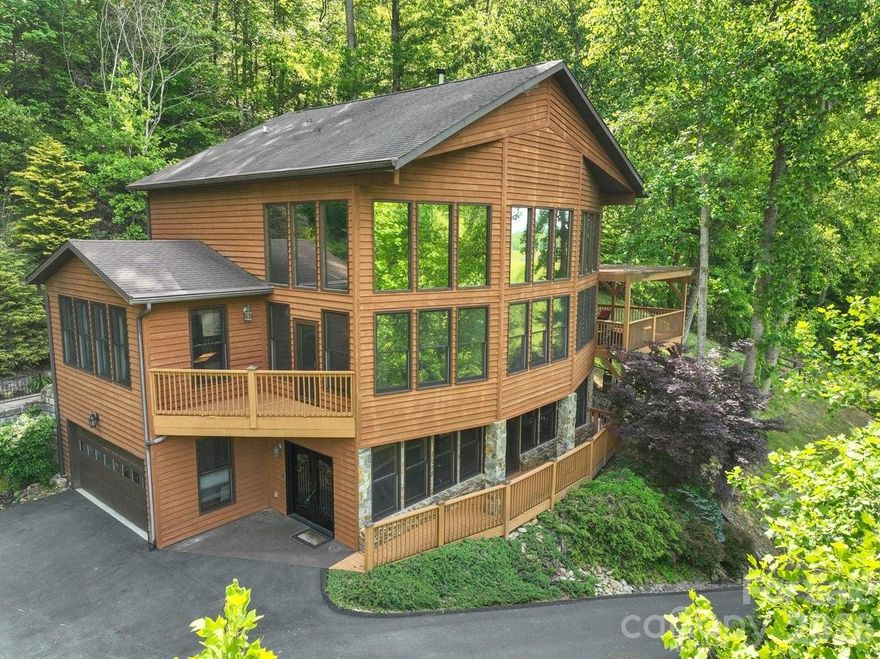 One of a kind mountain home situated on over 3.5 acres of lush landscaping. A stone patio and walkway lead to a large deck where you will enjoy stunning mountain and pastoral views. Inside, you will experience abundant space throughout the home and vaulted ceilings. A stunning stone, wood-burning fireplace is located in the main living area that opens up to a recently remodeled exquisite chefs' kitchen, which includes a dual fuel range, new craft ice making refrigerator, and new beverage refrigerator. Main level large primary bedroom with ensuite bathroom offers easy living. Upper level of the home has two ample-sized bedrooms and a full bathroom. Enter the lower level through the custom wrought iron door into the large great room with propane fireplace, wet bar, bonus room, and full bathroom. Added piece of mind includes whole home generator, whole home ultraviolet water system with softener. A two-car garage and two sheds to accommodate all your storage needs. The gated subdivision of Mountain Park offers a clubhouse for gatherings, fitness room, tennis courts, and many trails throughout for your pleasure. Come experience mountain living at its finest while only minutes from downtown Mars Hill and 20 minutes to Asheville.