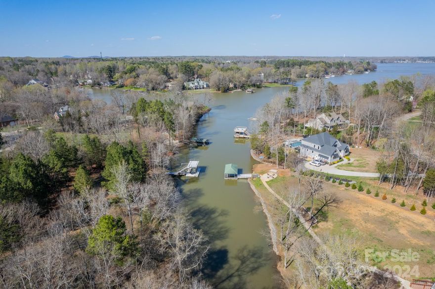 Immediate summer lake fun at this 1.385 acre, level, waterfront homesite on Lake Wylie in South Carolina. There is an existing double-decker dock permitted in 2001. Includes boat and jet ski lifts. Upper deck offers space for more company, extra activities, and fun! Use it immediately in 2024 to enjoy the lake! Lake Wylie main channel is moments away from this lot so you can enjoy the sandbar, Pappa Docs, & other lake destinations. This homesite is in South Carolina on a quiet road, with beautiful homes and quick access to Publix, Lowe's, Walmart, Carolina Thread Trail, botanical garden, city of Belmont restaurants/activities. No HOA! Owner had a home designed, septic permitted, ready to go, but life led them elsewhere. For a future home - as you enter the lot where the driveway would most likely be located, the septic was permitted to the right and home to the left in the flat area. There is a nice lake/water view toward the main channel from the home location. So much to offer!