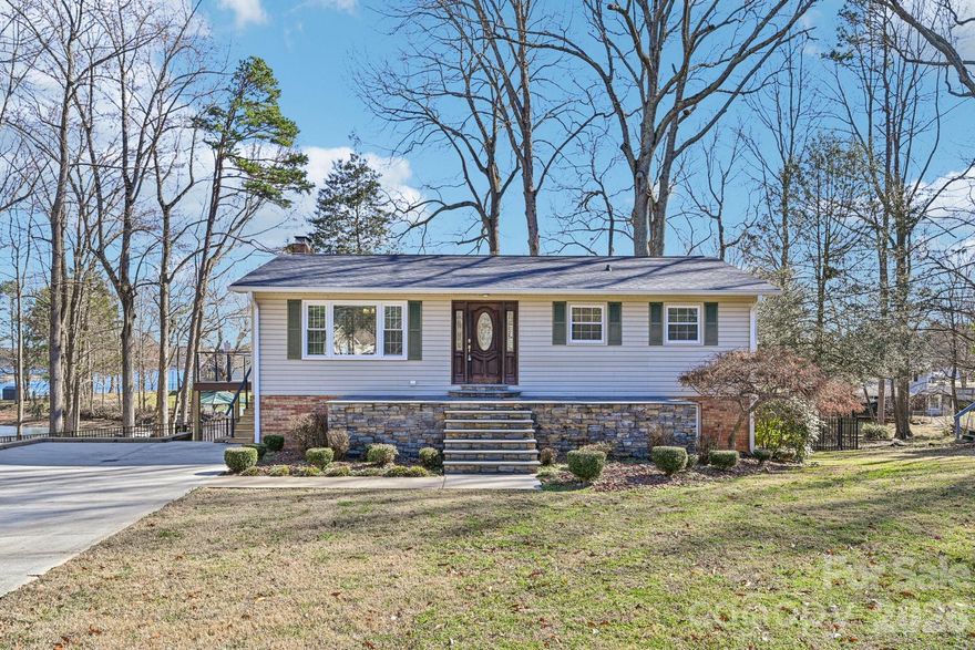 Welcome to this meticulously maintained waterfront retreat. Tucked away on a peaceful cul-de-sac with no HOA restrictions, this home combines privacy with convenience. Just bring your boat and start enjoying everything this home has to offer.
Boasting over 150 feet of shoreline, relax on the newly installed stone patio,deck or soak in the hot tub after a day in the sun. Enjoy effortless lake access from your private dock, complete with a newer High Tide 9,000-pound remote-controlled boat lift (2021). The fenced backyard provides a secure space for recreation and includes a storage shed for all your lake essentials.
Inside, the move-in ready home features a welcoming great room accented by crown molding and a striking stacked-stone feature wall. The kitchen captures beautiful lake views through new sliding glass doors that lead to an expansive wraparound deck. Highlights include abundant natural light, granite countertops, tile backsplash, tile flooring, and updated appliances such as a newer refrigerator and dishwasher. The dining area adds character with shiplap walls, a designer chandelier, and direct deck access.
The lower level offers a spacious recreation room with a built-in bar - ideal for hosting gatherings after a day on the water. The primary suite is also located downstairs and features a renovated bathroom with a large walk-in spa-style shower. A wood-burning fireplace with stove insert and blower efficiently heats the entire home during cooler months, and the chimney has been recently updated.
Other recent upgrades include a new water heater, gutters, hot tub, refrigerator and dishwasher.   Newer HVAC system (2023), whole-home water filtration system (2021).
Ideally situated both on and off the lake, the home is just minutes from dining, shopping, marinas, waterfront restaurants, schools, I-77, and more - offering the perfect blend of relaxation and accessibility.