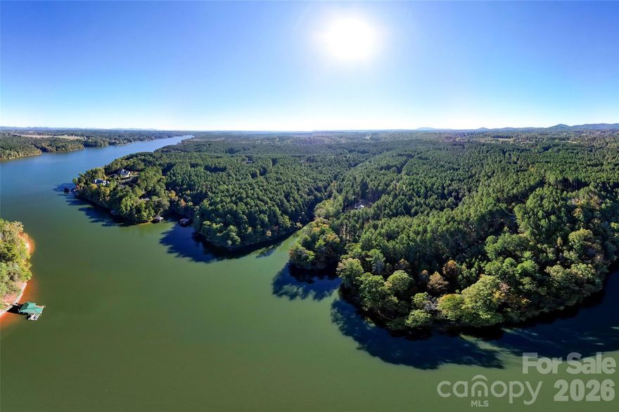 Affordable lakefront living is within reach! This waterfront lot on Lake Rhodhiss is ready for your lake adventures with a stationary Trex dock already in place. Nestled in a quiet cul-de-sac, Lot #266 offers privacy, beautiful hardwoods, and the perfect setting for a basement or walk-out home design. From your private dock, take in views of the main channel while tucked safely in your own peaceful cove. Located in a gated community with amenities including boat slips, a picnic area, and a lakeside fire pit, this homesite offers the ideal balance of recreation and relaxation. Lake Rhodhiss, part of the scenic Catawba River between Lake James and Lake Hickory, features 93 miles of shoreline and 3,060 acres of crystal-clear water for boating, fishing, and kayaking. With new homes under construction and a minimum build size of just 1,700 sq. ft., don’t miss this rare opportunity to own an affordable lakefront lot in the foothills of the Blue Ridge Mountains—your North Carolina lake life starts here!