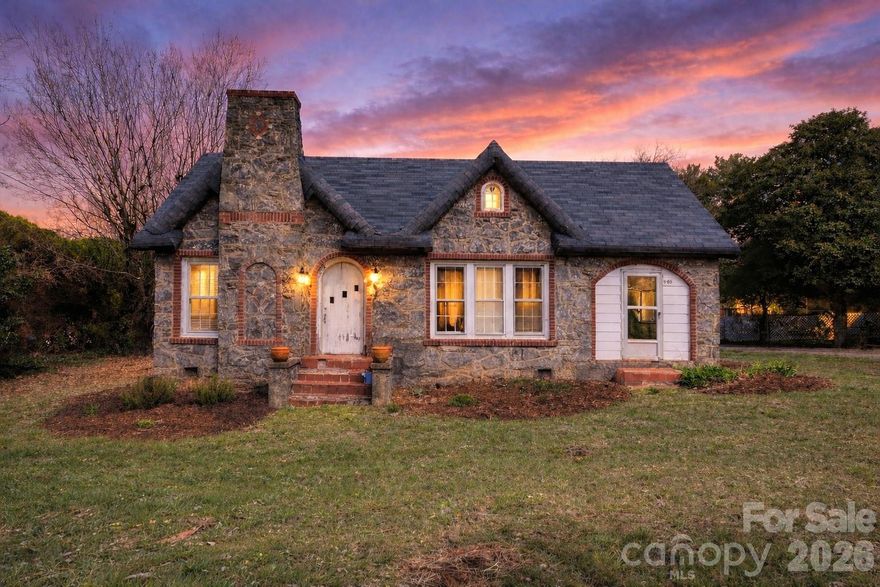 Charming stone cottage on 1.41 beautiful acres in Conover offering timeless character, usable land, and convenient access to everyday amenities. This inviting home blends classic cottage architecture with warm interior details, creating a property full of personality and potential.

Inside, you’ll find refinished hardwood floors throughout, fresh interior paint, and a layout that feels both comfortable and functional. The living room features a wood-burning fireplace, creating a cozy focal point for relaxing evenings. The dining area offers extensive cabinetry with unique see-through upper cabinets, providing both storage and visual charm rarely found in homes of this era.

The kitchen adds to the home’s character with a wood stove, bringing warmth and a nostalgic cottage feel to the heart of the home. Two bedrooms and a full bathroom provide comfortable living space, while the overall floor plan maintains the classic simplicity that makes cottage homes so appealing.

One of the most enjoyable spaces in the home is the enclosed side porch sitting area, complete with a porch swing — the perfect place to unwind while overlooking the peaceful property.

Outside, the property truly shines. The 1.41-acre lot is mostly level, offering an excellent combination of open yard space and mature landscaping. Approximately half of the acreage is well suited for gardening or growing vegetables, making it ideal for those seeking space for outdoor projects, hobby gardening, or simply enjoying a larger homesite. Crepe myrtle trees scattered throughout the front yard add seasonal color and natural beauty.

Additional exterior features include a large detached garage/workshop (approx. 910 sq ft) providing excellent storage or workspace potential, along with an additional tractor shed/storage building for equipment and tools.

Located just minutes from grocery stores, shopping centers, fitness facilities, and major conveniences, the property also offers quick and easy access to Interstate 40, making commuting simple while still enjoying the charm of a more spacious homesite.

This home offers solid bones, great character, and outstanding potential for buyers looking to personalize a charming cottage on acreage. Property is being sold as-is. Heating and air are functional.

Schedule your showing today and explore the opportunity this unique Conover property has to offer.