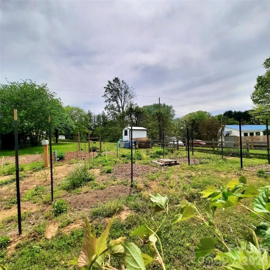 Multi-generational options here in charming 3 bed/1 bath main home, with 1/ bed/1 bath bungalow along w/almost 1/2 acre of organic garden or use as a buildable lot! Also option for vacation rental.  Most of he improvements/updates have been done for you, replacement windows in both homes, 2025 hot tub for fun, even a new septic system for the bungalow.  Walking distance to Jackson Park, and less than 5 minutes to Historic Hendersonville, but with NO CITY TAXES!  604 Substation Street is main home, 26 Calico Rock is separate USPS address.
Original hardwood floors in the cottage, large eat-in kitchen w/tons of cabinet & counter space, WBFP w/built in bookcases in living room, and a master that holds a king size bed.  Relax in the evening w/your glass of wine in the 3 season room, let Rover out to play in the fenced in yard, while you look out on your lush vegetables for tomorrow's dinner!  Life is GOOD!