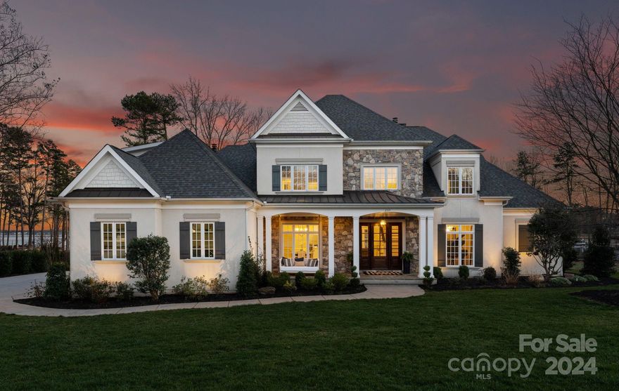 Indulge in lakeside luxury w/ this stunning two-story Cape Cod home with panoramic open water views! Enjoy effortless lake living in The Point w/ your own private beach, pier, and boat lift. The 2 story foyer opens to a light-filled great room w/ breathtaking views, a gas fireplace, coffered ceiling, custom shelving, and new flooring. The renovated kitchen features a 10.5-foot quartzite island, dual dishwashers, a gas range, & double ovens by Thermador, perfect for entertaining. The den adjoins the kitchen with a stone-covered gas fireplace overlooking the water. Double sliding doors lead to a large screened-in porch & flagstone patio for indoor/outdoor living. The main-level primary bedroom offers water views, and gorgeous en-suite bath. Upstairs there are three generously sized bedrooms w/ensuite bathrooms, along with a flex room and bonus room. Stunning views of the water can be seen throughout the home. Don't miss this opportunity.