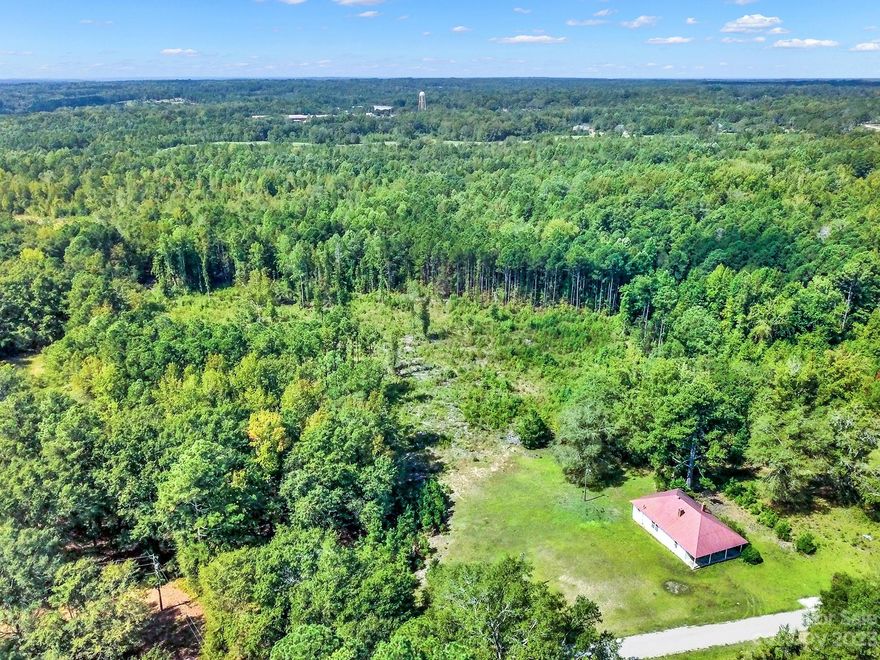 Country living at its finest!  Just shy of 8 acres get ready to build your dream home OR renovate the current structure on the lot! . Welcome home to this 1930's 3 bedroom farm style home. Enjoy the breeze while sitting on the front porch. Hardwood floors in great shape! Multiple fireplaces throughout. Third bedroom can also be used as a bonus space. Septic tank is on property but has not been serviced in years and seller makes no claim to its functionality.  Water is available, seller couldn't remember if it was city or county.  With some updating this could be an amazing place to call home. 36 miles to Rock Hill, 12 miles to Lancaster, and just 55 miles to Uptown Charlotte. Property is not in city limit.