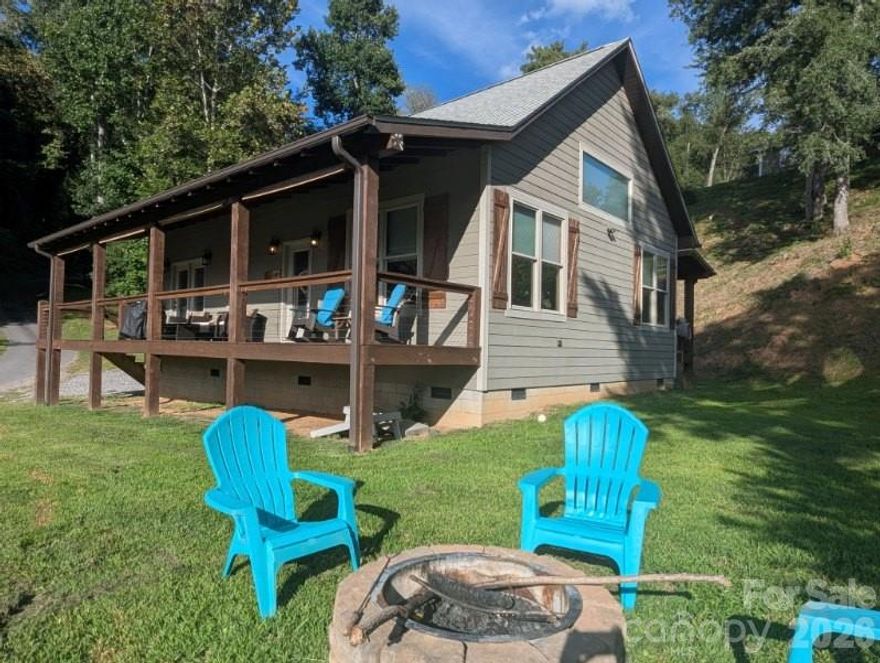 This beautifully furnished 2-bedroom, 2-bath home provides comfortable living on the Tuckasegee River. With modern finishes, thoughtful design, and numerous amenities, it’s perfect for both relaxing getaways and full-time residence. The included outbuilding offers additional storage and is 240 sq ft. The property’s proximity to local attractions and recreational opportunities makes it an outstanding choice for anyone seeking riverfront living. Close to WCU, Sylva, Dillsboro and Cherokee. Plenty of space for outdoor activities: play cornhole, relax by the firepit, or play in the water, fish or go tubing across the street to a strip of land that goes with this property or in the HOA common area. Currently used as a vacation rental. The kitchen features granite countertops, white custom kitchen cabinets, and an island with sink and dishwasher. Wood ceiling and wood and stone accent wall around the cozy fireplace. Wooden interior doors throughout the home. Primary bedroom includes an ensuite bathroom, double closets, and direct access to a covered porch with river views. Tiled shower extending to the ceiling with a clerestory window for natural light. Second bedroom is spacious, offering flexibility for guests or family. Second full bathroom with tub/shower and another clerestory window. Recessed lighting and full-size stackable washer and dryer. Hardy Board siding for low-maintenance living. Currently used as a vacation rental so book your appointment in advance. Home is not in the flood zone - just some lower land.