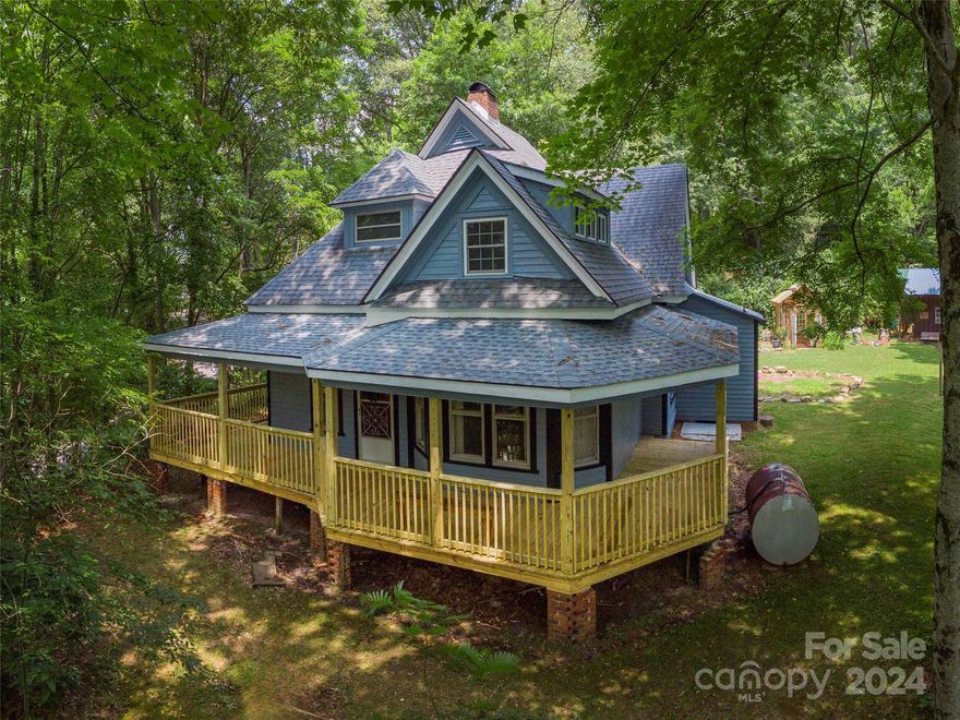Step back in time with this charming historical home, one of the oldest in Waynesville, on almost a full acre lot, just moments away from Main Street. This gem boasts updated electrical and plumbing, while also preserving its 1800s charm. The kitchen is a chefs dream with ample cabinet space and original farmhouse sink. The main floor features a cozy primary bedroom with an en suite bathroom, while the upper floor offers three more bedrooms and a bathroom, complete with a cast iron claw foot tub. Enjoy the intricate light fixtures throughout the home, original hardwood floors and doors, and a delightful wraparound porch. The property also includes a beautiful greenhouse, a separate workshop, and a custom kids' playground with a slide. Potential mountain views can be revealed with selective tree trimming. Don't miss this unique blend of history and modern amenities in the heart of Waynesville! 935sqft upstairs is not included in the total due to no permanent heat source.