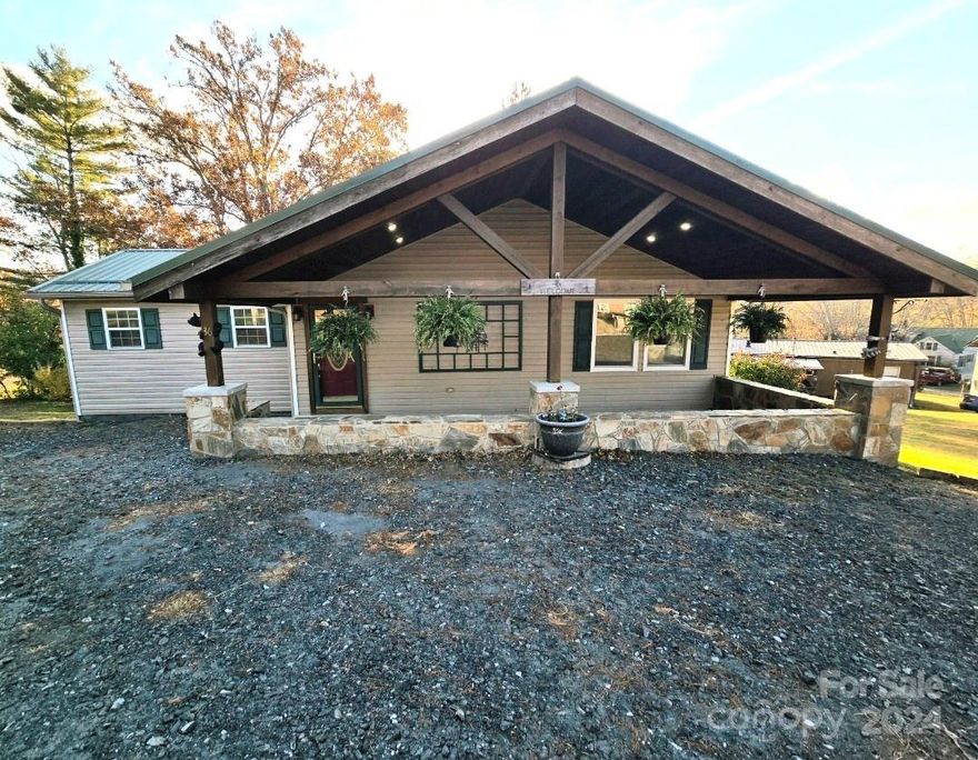 Welcome to your dream home in the city limits of Spruce Pine! This 3 Bedroom 2 bathroom residence offers the perfect blend of comfort and style. Enjoy stunning sunsets from the spacious deck, ideal for outdoor entertaining or quiet evenings. Step inside to discover an inviting open layout featuring granite countertops and custom spaulding maple cabinets in the kitchen with dinning room to itself. The primary bedroom boasts a luxurious tiled walk in shower, enhancing your daily retreat. Additional highlights include a gas dryer, a tankless water heater, plumbed for gas range and fireplace ensuring convenience and efficiency. Roof, guttering, back deck, primary bedroom and bath with laundry area were added aprx 9 years ago. New windows in 2023. Another plus is underground power lines at this home. One of my favorite things here is the covered rock front patio.