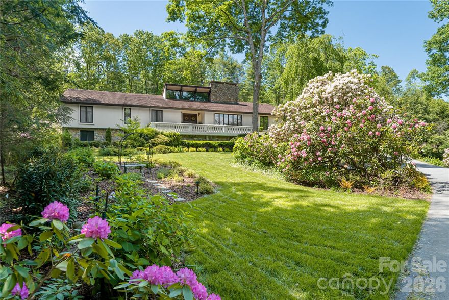 Live in your own resort, enjoying a heated deep swimming pool with slide and diving board, tennis and pickleball courts, basketball practice area, gym and steam bath on two acres showcasing a stone outdoor kitchen, water feature with fish pond, perennial gardens, fruit trees and berry bushes. A grand covered 65 foot long marble porch with three fans that adjoins the impressive stone patio and pool area with views to the tennis court, provides a tranquil setting. Invisible fence surrounds most of the property, while much of the back is enclosed by chain-link fencing. This fabulous home, bordering the famous Biltmore Estate, features six bedrooms and six baths, including two, three-room suites with outside and inside access, each comprised of a living room, bedroom and bath. Four bedrooms and baths on the main floor include the primary bedroom suite with three large walk-in closets, one 17-foot-long by 8-foot-wide, a spacious dressing room with semi-sunken oversized tub, two counters with sinks, dressing table, large skylight, tankless instant hot water, plus a separate water closet with steam bath/shower. An adjoining heated sunroom with glass ceiling and walls and outside access doubles as a greenhouse for wintering plants. The kitchen features custom-built cabinets, granite countertops, double ovens, a 6-by-6-foot quartz-topped island and an eating nook recessed in a bay window overlooking a garden. The oak paneled great room showcasing two antique chandeliers from Asheville's historic Battery Park Hotel, boasts soaring ceilings with wood beams, billiards area and wet bar. The large wood-burning stone fireplace that opens through to serve the immense dining room creates a timeless sense of grandeur. An adjacent cozy den with gas fireplace and bookcases offers a quiet retreat. A 700-square-foot office upstairs ensures quiet and privacy, while the smaller downstairs office offers convenience. Custom built-ins abound throughout this house set far back from the street and overlooking a manicured lawn with lush landscaping. The well thought-out floor plan, with majority of living space on the main level, has oak and wormy chestnut paneling, plaster walls, hardwood floors, cedar closets, carpeted bedrooms, a simply safe alarm system, tankless water heaters while the exterior features hard concrete stucco, traditional stone work, a red tile roof, outdoor lighting, irrigation using private well, potting shed, a new 22-kilowatt Generac generator and a renovated upper two-car garage with new epoxy floor plus a single lower garage. Three heat pumps provide heating and air conditioning. This is more than a home, it is a lifestyle of privacy and elegance in a secluded forested patrolled community minutes from shopping.