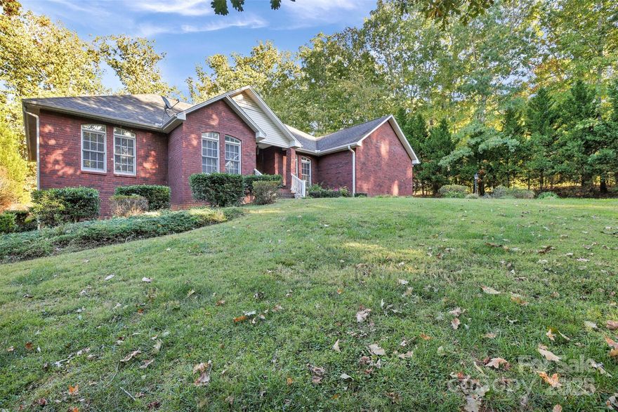 Nestled in the serene countryside, this charming home sits on over an acre of land while still offering convenient proximity to town. The inviting floor plan features split bedrooms for added privacy. The living room opens up to a lovely screened-in back porch, perfect for enjoying the outdoors. The spacious primary bedroom boasts a large en-suite bathroom, complete with walk-in closets and a separate tub and shower. Additionally, the basement offers a versatile space that can be transformed into a recreation room, as well as a garage area and a convenient half bath. This property beautifully combines the tranquility of country living with the ease of access to town amenities. Seller to give concessions for new flooring in kitchen. The house is being used as a four bedroom house, but per county records, septic is for only a three bedroom home.