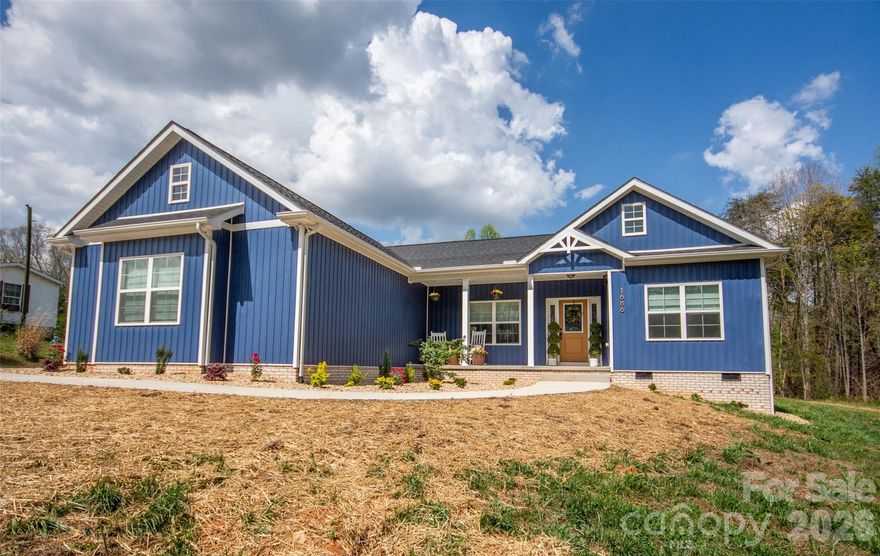 Adorable 3 BR, recently built, crisp and clean home on just over an acre in beautiful North Iredell Community. Large great room with cathedral ceiling. flooded with natural light!  Functional and open island kitchen, soft-close painted cabinets, granite, under-cabinet lighting, SS appliances, large pantry. Home has 9' ceilings, a large, tiled shower w/rainfall shower head in primary bath, spacious walk-in closet, dual vanity. Durable LVP in all common areas. The lot is private and deep so that the home is set off the road and there is a large level backyard the right size for play, entertaining, gardening, relaxation, sitting by the firepit or listening to the babbling creek that is just at the rear property line. Oversized garage with pull-down attic access and floored storage above and a new polyurea-coated floor.