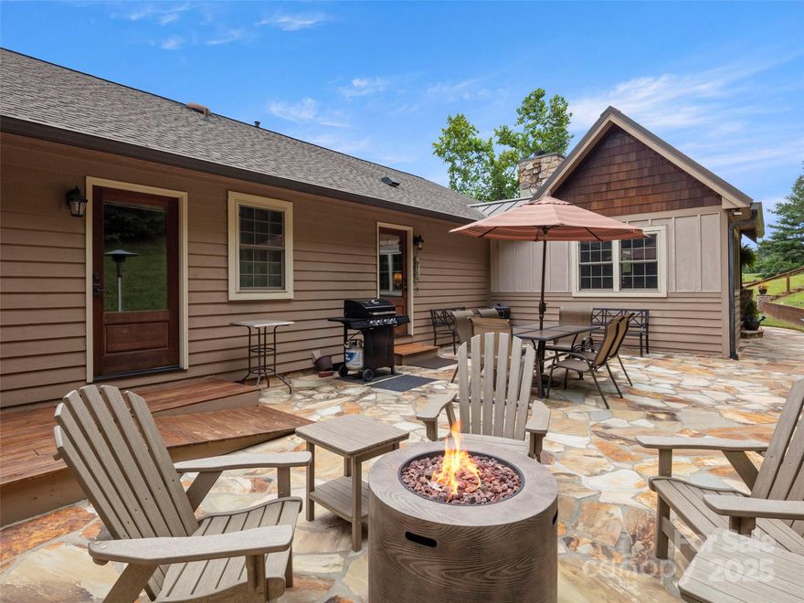 Perfectly positioned on 7.85 acres, this re-designed single level ranch is a true retreat. Enjoy private mountain views, a fully outfitted two-car garage, and a charming farmhouse that sets the stage for idyllic living. The main house showcases extensive upgrades, including artisan-crafted light fixtures, solid wood exposed beams, and a luxury kitchen with quartz countertops and floor-to-ceiling solid wood cabinets by Forest Millwork. Just off the chef’s kitchen, an expansive covered deck invites peaceful mornings with a cup of coffee or memorable evenings overlooking the gently sloping lawn and mountain backdrop. The primary suite features a fully renovated bath, while a generous office and guest bedroom complete the main living space. A separate lavish suite with private entrance and bar area—ideal for a future kitchenette—offers versatile accommodations for in-laws or guests. Designed with comfort and accessibility in mind, the home includes extra-wide door frames, a zero-clearance shower entry, and select automatic door openers. Outdoor living shines with a serene custom water feature, hot tub, and inviting flagstone patio. Across the breezeway, the two-car garage features custom doors and a workshop space. The barn accommodates up to three horse stalls and includes partial fencing, ideal for equestrian enthusiasts. Located just 15 minutes from Weaverville and 25 minutes to downtown Asheville, this estate blends privacy, convenience, and mountain charm—perfect for those seeking a quiet retreat with nearby dining, shopping, and more.