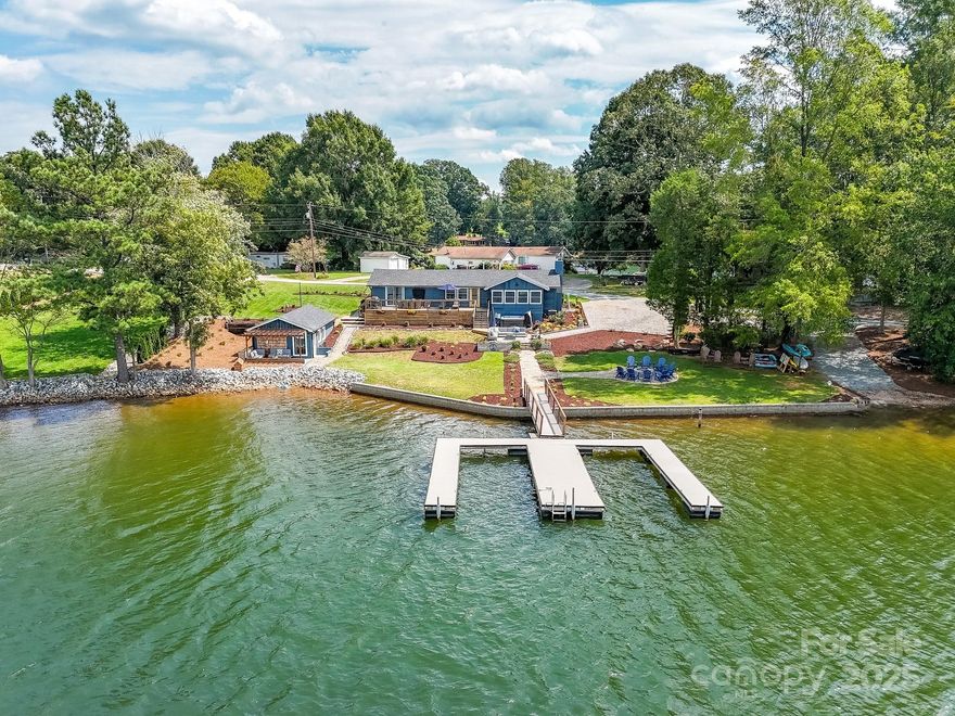 Back on market through no fault of seller. This is your chance! This property is a slice of heaven on Lake Norman! Vintage charm meets luxury lakeside living! This classic 1970s redwood post-and-beam cabin- now renovated for today's comforts- offers a rare opportunity on a stunning, serene cove of Lake Norman. Nestled on a .7 acre professionally landscaped private lot with approximately 265 feet of shoreline, you'll enjoy truly breathtaking sunsets and peaceful views year-round! This fantastic property includes a main residence as well as a "boat house" guest quarters, ideal for entertaining visitors, multigenerational living, or a successful investment property! The main residence features a gorgeous open-concept kitchen, living room, and dining room (with views for days), 2 spacious bedrooms, and 2 lovely renovated bathrooms + a 3rd bedroom/bunk space/office! Such thoughtful updates throughout with modern fixtures, a rustic wet bar, arcade area, and a striking antique stove-style fireplace that anchors the living space with warmth and nostalgia. Don't miss the wonderful boat house for a lakeside gathering space - complete with a kitchenette and full bathroom! The decks, hot tub, and gorgeous dock are perfectly poised for so much outdoor fun! The spacious yard even offers room for a pool! Recent improvements include the HVAC system, roof, appliances, flooring, well pump, septic system, hot tub, professional landscaping, expansive decks, and RV parking/charging station! A private launch ramp adds convenience for water enthusiasts! Sellers are willing to sell the property complete with the en trend furnishings and personal property (think arcade games, kayaks, and hot tub)!