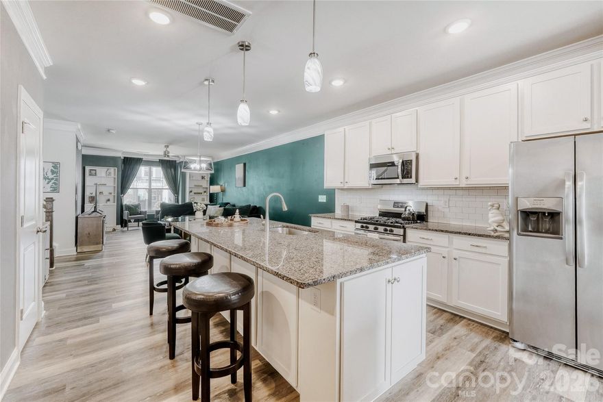 Beautiful 3-bedroom, 2.5-bath end-unit townhome in Mooresville just minutes from Lake Norman! Offering the perfect blend of comfort and convenience, this home features wide-plank LVP flooring throughout, stylish accent walls, and elegant crown molding that adds warmth and character. The kitchen is designed for both everyday living and entertaining, complete with granite countertops, an oversized island, abundant cabinetry, a gas range, and a custom beverage station — perfect for hosting or your morning coffee routine. A dedicated mini office nook makes working from home easy and efficient. Upstairs, the spacious primary suite includes a large walk-in closet with custom organizers and a dual-vanity bath. Two additional bedrooms provide generous space for guests, family, or flexible use. Enjoy relaxing or grilling on the private, fenced patio featuring low-maintenance turf — ideal for easy outdoor living.  Located just 1 mile to I-77 and the hospital, 4 miles to Downtown Mooresville, and 5 miles to Downtown Davidson. Stylish, low-maintenance living in an unbeatable location — don’t miss this one!