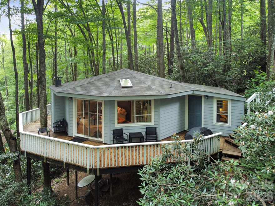 Tucked among the trees with a true treehouse feel, this charming roundhouse retreat in Mill Ridge captures the kind of mountain escape buyers are searching for—cozy, distinctive, and built for both enjoyment and income potential. This 2-bedroom, 1-bath home stands out with its unique circular design and inviting interior, creating a warm, memorable space that guests love. Currently operating as a proven short-term rental, it offers strong appeal as a guest-favorite retreat with income potential and flexibility for personal use. Financials available upon request. Inside, the efficient layout lives comfortably with a natural flow between living, dining, and kitchen spaces—great for unwinding after a day in the mountains. Large windows bring in natural light and reinforce that elevated, treehouse-like experience that photographs beautifully and keeps guests coming back. Step outside to the wraparound deck and you’ll immediately see why outdoor living is the highlight—surrounded by woods and offering a tucked-away setting that’s hard to find. It’s a great spot for morning coffee, evening drinks, and seamless indoor–outdoor living. Located in the amenity-rich Mill Ridge community with access to a pool, playground, and tennis courts, and just minutes to Sugar Mountain, Beech Mountain, Banner Elk dining, and Boone—plus endless hiking and outdoor adventure—this property is positioned for both personal enjoyment and consistent rental demand. A low-maintenance, proven performer in one of the High Country’s most desirable areas—ready for immediate use, rental, or both.