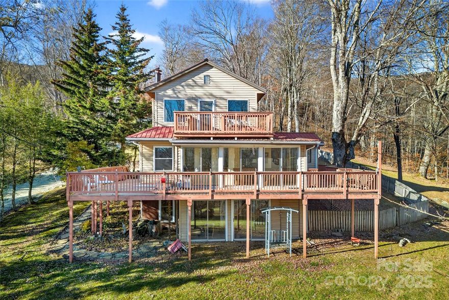 Nestled inside the Valley of the Roan—just before you reach the breathtaking Appalachian Trail on Roan Mountain—this home perfectly captures the balance of mountain living + mountain charm.. A contemporary build with cozy cabin undertones, it offers the best of both worlds: comfort, creativity, and connection to nature.

Step inside and you’ll find bright, open spaces that invite inspiration. The main level features a spacious living area with winter mountain views, a two-car garage, and a dedicated artist studio where the current owners painted and crafted woodwork. Upstairs, a loft offers extra room for guests, hobbies, or a peaceful home office. From the loft, follow the runway-style walkway to your own private porch—an incredible spot to take in the mountain air and gaze out toward the gazebo and porch swing below. In the basement, you will find your hot tub to enjoy while it snows and a finished basement area with a large living area, full bath, laundry, and an office. 

If you’ve dreamed of living near Roan Mountain’s hiking trails while having space to create, this home delivers it all. And for those with an entrepreneurial spirit, the sellers are also offering their commercial property in downtown Bakersville at 37 N Mitchell Avenue—the perfect opportunity to blend mountain living with a mountain business.
Your  Mountain lifestyle starts in Mitchell!