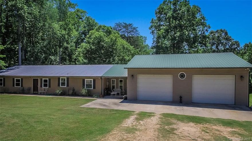 Huge garage over 1100 sqft! Workshop, car mechanic, or business owners dream! No HOA and on over an acre of wooded land. Plenty of room for all the boats, cars, RV's and toys! Single story with 2 bedrooms w/ attached baths and large walk in closets. Large kitchen with eat up counter and pantry. Brick fireplace in den. Has handicap accessibility.Wood deck out back to enjoy private yard. Low maint. metal siding & roof. Newer HVAC, well, water heater & windows. All appliances included! See 3D Tour.