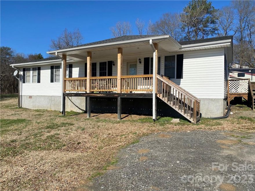 Four Bedroom Ranch Style Home situated on a 1.07 Acre Lot in Mt Holly. Home sits perched on top of a ridge, with a rocking chair front porch overlooking the huge front yard. Spacious Living Room & Kitchen/Dining Room combination. Kitchen/DR has newer laminate wood flooring. Kitchen features updated laminate countertop, stainless steel sink & includes a free standing electric stove, side by side refrigerator, dishwasher. Hall Bath has been completely updated, including ceramic tile floor & tub surround, cabinets, sink, commode, etc. Ceiling fans throughout home. City water, but no city taxes. Improvements include roof 2015, water heater 2021, rear deck/steps 2020, front porch columns/railings 2022, complete septic system 2022, heat pump 2015, Kit/DR flooring 2021.  There is still work to be done, such as carpet, interior painting, etc.  This would be a perfect opportunity to make improvements & greatly increase new owner's equity. Sellers prefer to sell 'as is'.