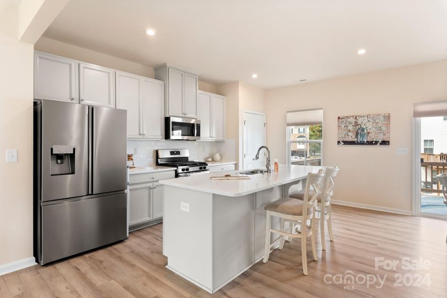 Premium END UNIT townhome adjacent to a large common area, on a cul-de-sac, AND zoned to Award Winning Fort Mill Schools! Built in 2021 this home has been meticulously maintained and hardly lived in! BRIGHT white kitchen with large island for cooking and entertaining, separate dining area, and large gathering space make this townhome live like a single family home! Balcony off the kitchen and additional windows provide plenty of natural light! Light colored and durable LVP floors throughout the main living space and upgraded hardwoods on the stairs! Third level with three bedrooms, two full baths, and laundry room. Lower level recreational room with multiple uses and access to a covered, private patio.  Two car garage with its own AC unit beautifully cools the garage and the finished walls/floors make it ready for multiple uses - a workout room, additional living space, or even an art studio! Tucked away in a quiet neighborhood and next to the walking trails, yet quick access to I-77!