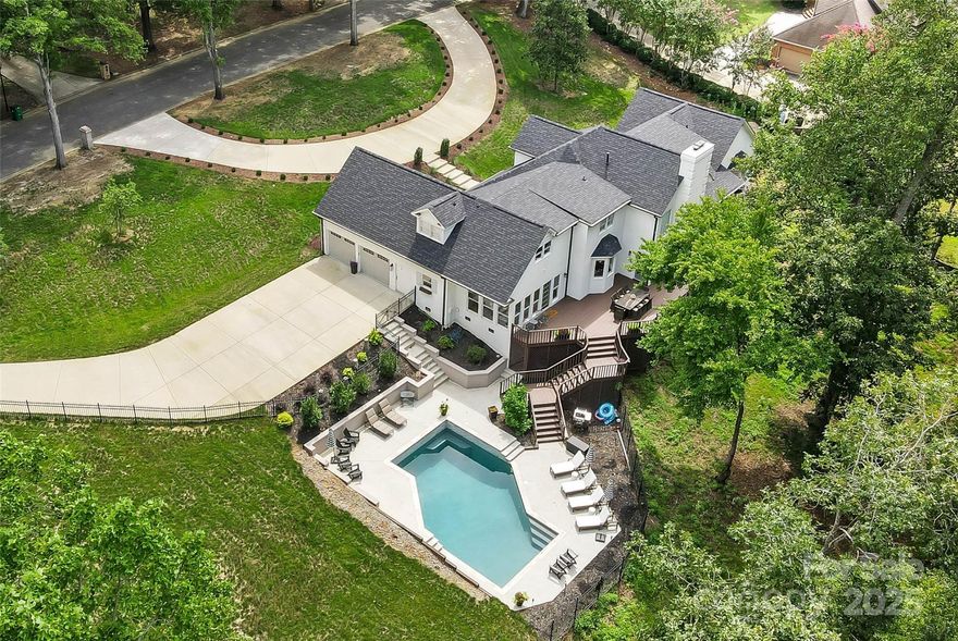 Elegant European-Style Estate in Greyson Heights. Discover timeless sophistication and modern comfort in this distinguished European-inspired residence, set on a rare 1.81-acre double lot with a private wooded backdrop. Perfectly positioned in one of South Charlotte’s premier locations, this estate offers both seclusion and convenience, with no HOA.

Step inside the soaring foyer and you’re greeted by expansive living spaces designed for entertaining and everyday luxury. The main level features a grand primary suite with dual walk-in closets, a spa-like primary bathroom, large sauna, and a walk out deck with private sitting area. A gracious great room with wood-burning fireplace flows seamlessly into the formal dining room, keeping room, and chef’s kitchen—complete with double ovens, gas cooktop, walk-in pantry, wet bar and bright breakfast area. A large laundry room with custom cabinetry adds unmatched functionality. The 5th bedroom / guest room was added in 2024, but it could also function as a second office, craft room or sitting room. This room does not have its own closet, but is a perfect spot for guests and has space for a closet to be added if desired.

Upstairs, find three spacious bedrooms, two full baths, and a large bonus room—ideal for media, recreation, or additional living space. Dual walk-in attics and central vacuum highlight the home’s thoughtful design.

Outdoor living is a true showpiece: an expansive deck and rear porch overlook a sparkling saltwater pool that was resurfaced with pebbletec and new travertine coping in 2024. This private oasis is surrounded by lush landscaping, in-ground irrigation, and wooded privacy. Two separate driveways—including a newly paved circular drive and a second new and separate driveway that connects to the garage entry. The garage entry is conveniently stepless, an easy way to enter the main living area. 

Recent updates ensure peace of mind, including a brand-new roof (2024) and three new HVAC units (2024). Additional features include tankless water heater, newly refinished hardwoods which now extend through the second floor, high ceilings, and upgraded lighting and fixtures. This home also connects to city water and sewer — rare luxuries in such a private setting with no HOA.

This is more than a home—it’s a lifestyle. A rare opportunity to own a South Charlotte estate that blends elegance, freedom, comfort and privacy in one of Charlotte’s most coveted communities.