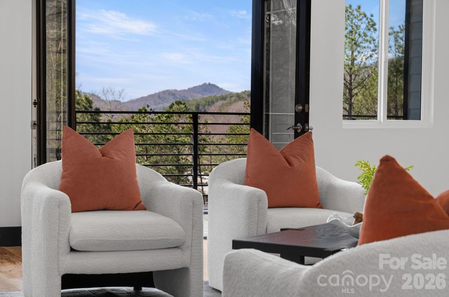 Luxury mountain living just minutes from Pisgah National Forest.
Located one mile from Turkey Pen Gap Trailhead and a short drive to Brevard, Hendersonville, and Asheville. This beautifully designed 4,000+ sq ft mountain home offers fireplaces, spa-like bathrooms, outdoor entertaining spaces, and year round mountain views all surrounded by some of the best hiking and biking in Western North Carolina. Imagine waking up to mountain views and stepping outside to some of the best outdoor recreation in Western North Carolina with hiking, mountain biking, river walks, and horseback riding practically in your backyard.

The first level welcomes you with a stone fireplace and built-ins, creating a cozy living area that could also function as a game room or entertainment space. There is plenty of room for a pool table, lounge seating, or even a bar area for hosting gatherings and celebrations. This level also features an additional primary bedroom suite with a corner fireplace and sliding doors that lead directly to the patio that is already set up for a future hot tub. The spacious spa-inspired bathroom includes dual vanities and a dramatic walk in shower that surrounds a soaking tub, creating a true retreat experience. A large walk in closet with washer and dryer hookups makes this level perfect for a guest suite or in-law living area.
As the illuminated staircase leads you upstairs, the second level opens up to beautiful south facing mountain views. The chef’s kitchen is the centerpiece of the home, anchored by a stunning waterfall granite island designed for cooking, gathering, and entertaining. CAFÉ™ ENERGY STAR® appliances, a hidden pantry, stainless range hood, and pot filler add convenience while maintaining a sleek, modern aesthetic. Cabinet lighting automatically illuminates when opened, and gold hardware paired with the marble tile backsplash adds a touch of luxury.
French doors open to a large covered deck, creating a seamless indoor/outdoor flow between the kitchen, dining area, living room, and outdoor entertaining space to perfectly host friends or enjoying quiet mountain evenings. A second laundry room and half bath are also located on this level for added convenience.
The main-level primary suite features a fireplace with a comfortable seating area and stunning mountain views right from your bed. The en-suite bathroom offers a soaking tub, large walk-in shower, and generous space to unwind after a day exploring the mountains. Two separate closets provide abundant storage for seasonal wardrobes and linens.
The third level offers incredible flexibility for modern living. A bright area at the top of the stairs works perfectly as an office, reading nook, or creative workspace. Nearby, a spacious room could serve as a fourth bedroom, studio, nursery, or additional office space, complete with a walk-in closet and nearby full bathroom.
Another large room on this level offers the perfect bonus space for a family room, game room, or kids’ hangout. French doors lead to a private deck where you can enjoy long-range mountain views year-round.
Also on this level is the third bedroom suite, featuring its own fireplace, seating area, walk-in closet, and private bathroom with dual sinks and a walk-in shower.
Outdoor living is just as impressive as the interior. Multiple decks and patios create inviting spaces to relax and take in the surrounding mountain scenery. The landscaping is designed for low maintenance living, while arborvitae trees provide backyard privacy without blocking the front mountain views.
Schedule your showing today and experience mountain living at its best.