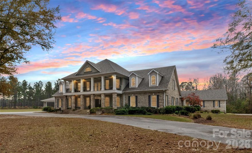 Discover an uncompromising level of Southern luxury in this extraordinary 10,000+ sq ft estate set on 10 peaceful and private acres in Kershaw, ideally positioned between the historic charm of Camden and the convenience of Lancaster. A beautifully designed circle drive—finished with elegant pavers at the entrance—guides you past the stately port-cochère and into this distinguished residence, accompanied by three complementary structures: an all-brick workshop, a classic barn, and a charming outbuilding.
Inside, sophistication unfolds across expansive living spaces, where refined craftsmanship and timeless architectural details create an atmosphere of quiet grandeur. The home boasts three full kitchens in the main house and multiple laundry rooms, offering unmatched convenience and versatility for hosting, multigenerational living, or everyday ease. Three distinct wings provide flexibility for guests, private offices, or creative spaces, while a private in-law suite features its own garage and separate entrance for added independence.
The primary suite is a sanctuary of its own, complete with a private library and luxurious his-and-hers bathrooms, each thoughtfully designed for ultimate comfort and indulgence. The dramatic foyer, framed by soaring ceilings, features a light lift providing effortless access to the chandelier—a refined touch perfectly suited to an estate of this caliber.
Outdoor living takes center stage. A sparkling, heated, and chlorinated pool is complemented by an impressive pool house offering a full kitchen, full bath, wood-burning fireplace, and outdoor shower. Beneath the pool house, a pull-through garage adds both convenience and functionality. Multiple screened-in porches invite seamless indoor-outdoor living throughout the seasons.
This remarkable property features 8 bedrooms, 9 full bathrooms, and 2 half baths, ensuring ample space for family, guests, and hosting in complete comfort. The home is further enhanced by numerous recent upgrades, including a new roof (2025), six HVAC units (two from 2020, one from 2021, one from 2022, one from 2025, and the pool house unit from 2009), and five water heaters—three tankless units from 2020 and two 40-gallon electric water heaters from 2009.
Please note: the property’s well pump is not currently operational.
A rare offering of privacy, craftsmanship, and timeless Southern elegance, this estate is more than a home—it is a lifestyle, a retreat, and a legacy. Due to limited photos in MLS, ask your agent for an unbranded link to view all photos.