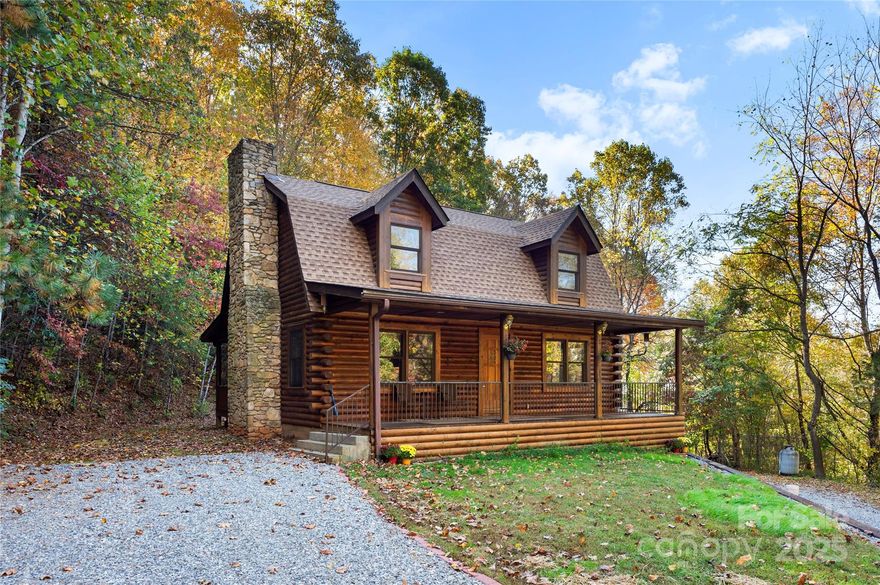 HERE IT IS! Your charming mountain cabin in the countryside. Located at 5 Rustic Ridge Dr, this quaint log home sits on a spacious, level, and private lot in a peaceful neighborhood near Asheville. The inviting full-length rocking chair porch welcomes you as you arrive.

Inside, warm wood tones and beamed ceilings create a space that feels both expansive and cozy. The main level features a beautiful rock gas-log fireplace, a dining room, a kitchen with a portable island, and a guest half bath. Upstairs, there are 3 cozy bedrooms with angled ceilings adding character and a full bathroom. Each room has its own controlled baseboard heat, and the baseboards were recently cleaned. Filter on well has been changed monthly.

Additional amenities include a backup generator to keep everything running smoothly during inclement weather. The nice level yard provides enough space outdoor activities and endless fun. 

With no restrictions, this property offers limitless possibilities for living, vacationing, or generating income. Don't miss out on this exceptional mountain retreat!