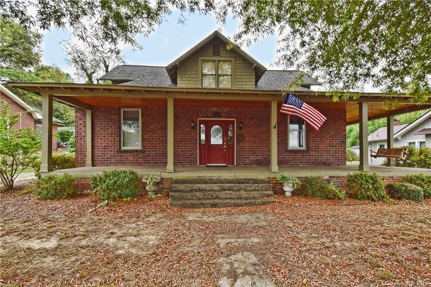 Adorable home w/huge wraparound front porch. Tile flooring in the kitchen, dining room & bathrooms. The kitchen has been recently updated. Extras also include hardwood flooring, high ceilings & a large utility room. Enjoy cozy evenings in the living room featuring a gas fireplace. This home has an in-ground swimming pool. And for lots of privacy, this property has a fenced backyard. If you need storage, this home has an outbuilding/storage shed. Walking distance to downtown, restaurants & shops.
