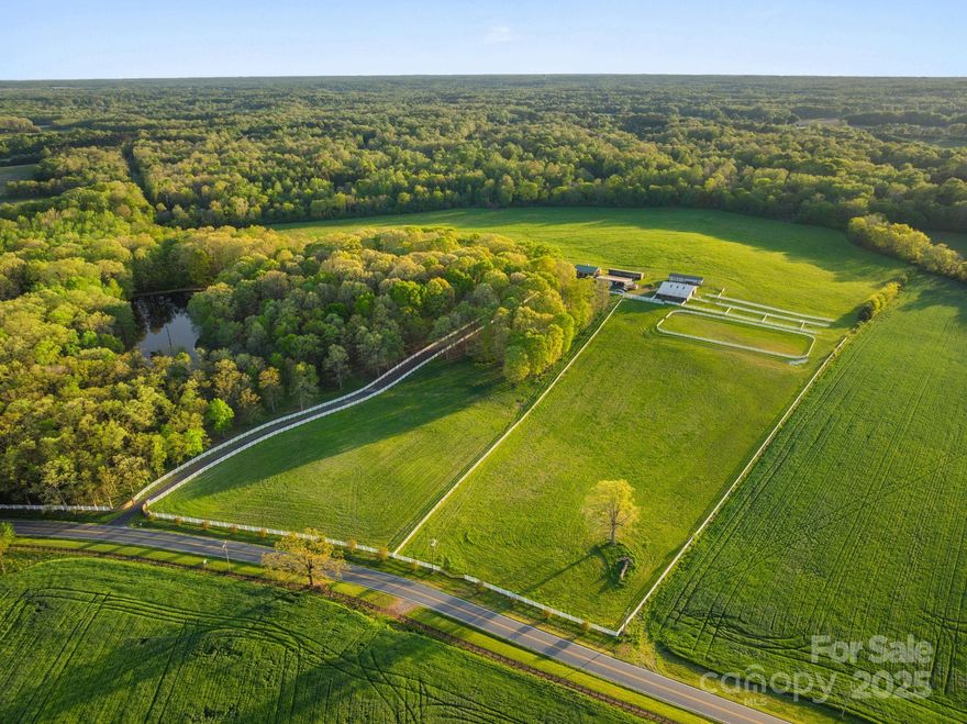 Welcome to Rocky Top Farm! As you enter the 76.9 acre property through the grand gate & drive along the white fence-lined driveway, you’ll be greeted by expansive pastures surrounded by white fencing. This estate includes a brick, one-level home with a basement. The property encompasses multiple outbuildings designed to meet all your storage & equipment needs. The large red barn boasts roomy stalls, automatic waterers, & restroom. There’s ample space for your horses & equipment. Rocky Top offers endless possibilities for farming or recreational use. Spend your day fishing off the dock on the stocked pond or enjoy the peaceful swing by the water’s edge. The surrounding woods provide tranquility. The property includes a mobile home, providing additional housing for guests or staff. This farm is the ideal setting. Situated in a prime location just minutes from Interstate 485, this property offers easy access to all that Charlotte has to offer. A perfect balance of privacy & convenience.