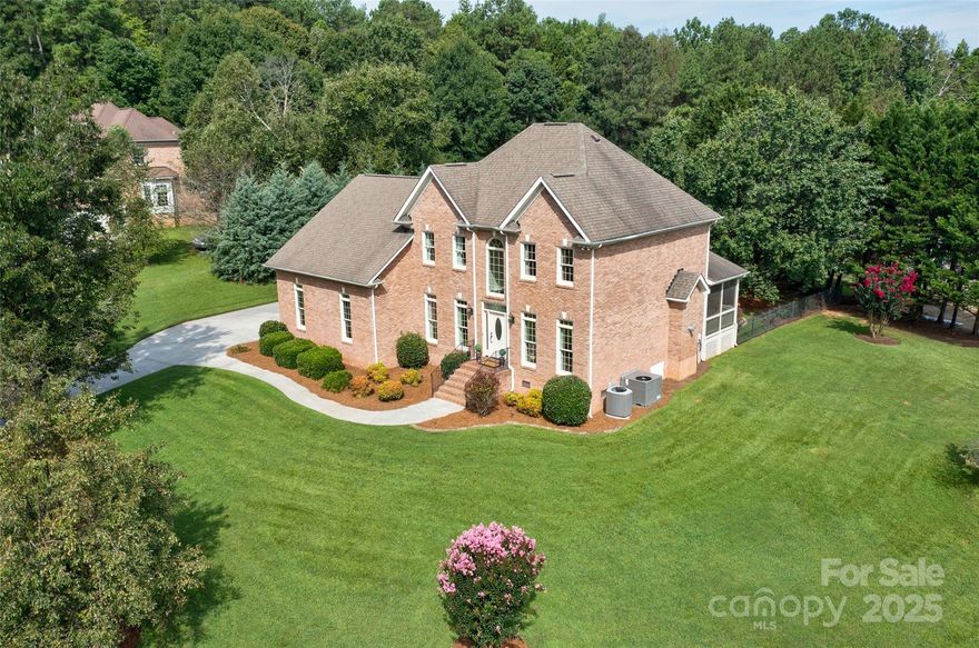 Located in the highly sought-after Huntington Farms community of Fort Mill, this pristine full-brick home sits on a beautifully landscaped corner lot of approximately one acre. Meticulously maintained by its original owners, this 3,008 sq ft residence offers timeless style and exceptional livability.

Built in 1999, the home features four bedrooms and three full bathrooms, with a well-designed layout that blends comfort and function. The main level boasts an open floor plan with clear sightlines from the grand two-story foyer—highlighted by an arched window—through to the spacious great room, kitchen, and breakfast area.

Elegant architectural details include decorative columns, multi-piece crown molding, 9-foot ceilings on the main level, and designer lighting throughout. A flexible main-floor office/bedroom offers additional living space options.

Upstairs, the impressive primary suite includes a tray ceiling, a spa-inspired bathroom with frameless tile shower, garden tub, and dual vanity with granite countertops. Two additional guest bedrooms, a full bath, and a large bonus room complete the second level. You'll also find two sizable finished walk-in storage closets and walk-in attic space for all your storage needs.

Numerous upgrades enhance the home, including Pella windows throughout and a Pella leaded glass front door with matching sidelights. Most window treatments (excluding the primary suite) convey with the property. TVs and select furnishings are negotiable.

The 2-car side-load garage is equipped with a 240V EV charging outlet. Step outside to a spacious paver patio that leads to a fully fenced backyard with mature trees, lush landscaping, and landscape lighting. A Bluetooth-controlled irrigation system ensures easy maintenance. There’s plenty of space to add a pool, and the detached utility building is perfectly positioned to serve as a future pool house.

Fort Mill is one of the Charlotte region’s most desirable suburbs, known for top-rated schools, a vibrant downtown, and access to the Anne Springs Close Greenway. A perfect blend of small-town charm and modern convenience.

This move-in-ready home offers the ideal combination of quality construction, thoughtful upgrades, and location. A true gem in Huntington Farms.