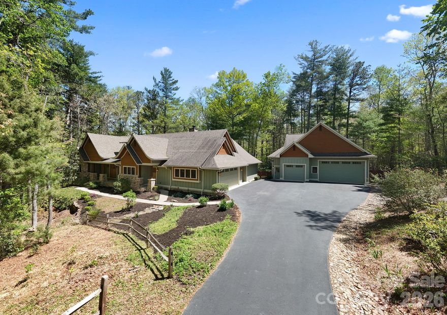 Framed by a canopy of mature trees and artfully naturalized grounds, this bespoke Arts & Crafts residence set on 3.1 acres offers just under 3,400 square feet, with 4 bedrooms, 4 full baths, and 2 half baths - thoughtfully scaled for entertaining and effortless living in Fletcher’s desirable Cane Creek valley, conveniently located between Asheville and Hendersonville. From the moment you arrive along the tree-lined approach beside Taylor Ranch, where dappled sunlight filters through the canopy and longhorn steer graze against soft mountain vistas, the setting unfolds slowly and deliberately, offering a daily reminder that you are somewhere distinctly different.

A welcoming stone porch opens to a gracious foyer and central living space, intentionally designed for both intimate moments and elevated entertaining. The kitchen is a true showpiece, anchored by an oversized island and appointed with solid wood cabinetry, a walk-in pantry, and a six-burner gas range with griddle and heat-lamp hood. It flows seamlessly into the family room, where custom built-ins, a striking stone wood-burning fireplace, and a well-appointed wet bar create an inviting atmosphere. Casual and formal dining spaces offer versatility, while a refined FLEX ROOM provides the perfect setting for a private office, library, or den.

Wake to serene wooded views in the main-level primary suite, complete with a gas fireplace, dual dressing rooms, and a spa-inspired bath designed for true relaxation. A separate wing offers two additional spacious bedrooms and bathrooms, while upstairs, a second primary suite with sitting area and en suite bath provides exceptional flexibility for multigenerational living, guests, or a private studio.

Thoughtful daily conveniences, including a discreet “friendship entry,” drop zone, a generous laundry room, and a tool shed enhance livability without compromising design. Outdoor spaces are equally compelling: a screened and covered deck immersed in the trees, and a broad stone patio with a recessed four-seat hot tub create a private, resort-like retreat ideal for year-round outdoor living.

The detached oversized three-car garage includes a 10-foot door, epoxy flooring, half bath, mini-split, and unfinished loft/attic, offers endless potential for a studio, workshop, or additional living space. Modern systems, including a whole-home generator, tankless water heater, radon mitigation, moisture control in the crawlspace, and integrated Control4 audio, provide comfort and peace of mind.

Set within the private gated community of Ashbrook, with wooded walking trails, this residence offers a rare balance of seclusion and accessibility just minutes from Asheville and Hendersonville’s dining, shopping, breweries, outdoor recreation, healthcare, and the Asheville Regional Airport. Enjoy year-round outdoor living with nearby hiking and mountain biking, along with space to garden and engage with the natural surroundings. Schedule a private tour today.