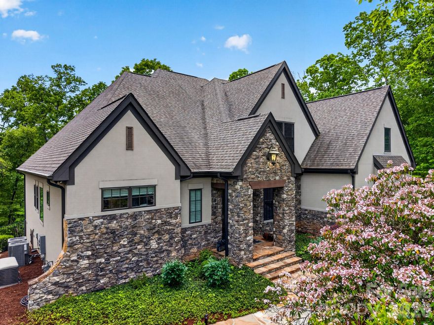 Luxury Mountain Home in the gated Homestead at Mills River — a private 1.5-story residence set on a wooded homesite, with an additional 23 acres available. Offering over 4,000 heated square feet above grade, plus a heated basement, this custom home by AR Homes delivers refined mountain living in one of Western North Carolina’s premier private communities.
Thoughtfully designed, the home blends architectural detail, spacious interiors, and exceptional indoor-outdoor living. The main level features a primary suite with walk-in closets and a spa-inspired bath with heated floors. The great room showcases a coffered ceiling, stone fireplace, and a retractable glass wall that opens seamlessly to the back deck—creating a true indoor-outdoor experience.
The chef’s kitchen is appointed with custom cabinetry, stainless appliances, and a large walk-in pantry with built-in shelving and drawers. Oversized, fully integrated refrigerator and freezer columns are paneled to match the cabinetry for a seamless, high-end finish. A formal dining room, powder room, mud/drop zone, and main-level laundry complete the space.
Designed for year-round enjoyment, the outdoor living area includes a covered deck with retractable screens, retractable porch swings, built-in natural gas grilling, and an outdoor gas fireplace. A flagstone firepit area and fenced backyard enhance both privacy and usability.
Upstairs, three generously sized bedrooms each offer en-suite baths and walk-in closets, along with a loft/flex space, media room, and access to substantial unfinished storage. A finished bonus room over the garage and a second laundry room add flexibility and convenience.
The home also features a wine room, multiple wet bars, and a rare dual laundry setup with both main-level and upper-level laundry rooms. A private office/den includes built-in under-counter dog crate space and a pet door with direct access to the fenced yard.
Recent upgrades include a whole-house water filtration and reverse osmosis system, fully encapsulated crawlspace with dehumidification system, and two tankless water heaters. A whole-house generator (excluding oven and dryer) provides added peace of mind.
Additional highlights include natural gas service, conditioned storage space below the deck, and a newly installed greenhouse—offering a unique lifestyle and gardening opportunity.
Located within the gated Homestead at Mills River, residents enjoy private roads, wooded surroundings, abundant wildlife, and exclusive access to a 10+ acre riverfront clubhouse along the Mills River—ideal for gatherings, fishing, and outdoor recreation. Conveniently positioned near Asheville, Hendersonville, Brevard, and just minutes to the regional airport.
A rare opportunity exists to purchase an additional 23 adjoining acres outside the HOA with no restrictions, offering potential for a private estate, family compound, equestrian use, or future investment. Access is available via ROW easement from South Mills River Road.
This property offers an exceptional combination of craftsmanship, privacy, and flexibility in one of Mills River’s most sought-after communities.
