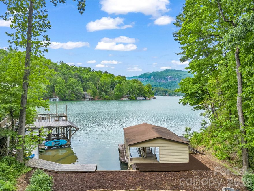Exceptional lakefront opportunity in one of Lake Lure’s most sought-after locations! Breathtaking, unobstructed mountain views and the rare luxury of a true lakeside yard, an almost unheard-of feature on Lake Lure! Designed to maximize outdoor living, with a brand new two-story Trex deck (installed 2026), creating the perfect setting for entertaining, relaxing, and taking in the stunning mountain and water views. Whether enjoying morning coffee or evening sunsets, this home delivers an unparalleled connection to the lake. The gentle yard extends to the water’s edge, offering easy access for lakeside activities and a setting ideal for gathering with family and friends. With its prime location, remarkable views, and unique outdoor space, this property presents an extraordinary opportunity to own a distinctive piece of Lake Lure for a full-time mountain experience or a lucrative income producing vacation home! The lake is OPEN and your front row seat is waiting!