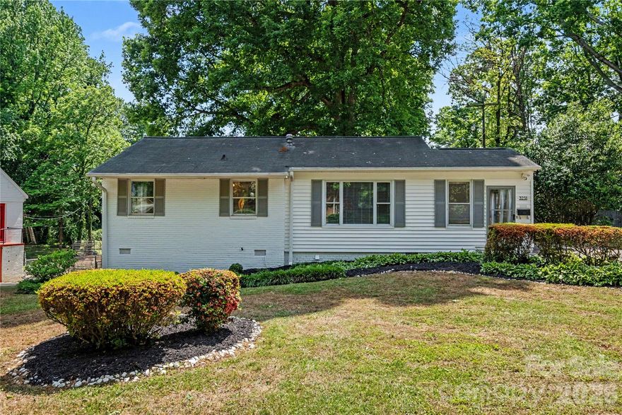 3231 Eastwood Drive is a 3-bedroom, 2-bath ranch with a finished basement suite and private exterior entry, set on a mature, tree-shaded lot just minutes from NoDa and Plaza Midwood.

The 966sf main level is designed for everyday living that feels intentional. A bright enclosed sunroom welcomes you in -ideal for morning coffee or a quiet work-from-home setup- before opening into the main living area where natural light carries throughout. Hardwood floors run through most of the main level, and the kitchen features white flat-front cabinetry, stainless steel appliances, and a stacked stone-and-glass mosaic backsplash.

Two spacious bedrooms and a full bath are positioned on the main level, along with a flexible room that works well as a dedicated office, dining space, or creative studio - giving you options based on how you live. A second enclosed three-season room off the kitchen adds additional lounge space and connects directly to the rear deck, creating an easy indoor-outdoor flow.

Out back, a fully fenced yard, in-ground firepit, and mature tree canopy create a setting that feels private and usable year-round -whether you’re hosting friends or enjoying a quiet evening at home.

The 856sf finished basement offers a fully suite-style layout with its own exterior entry - ideal for guests, multigenerational living, or rental use. The layout includes a large living area, bedroom, full bath, flex room, and wet bar. In 2024, the space operated as a successful Airbnb with consistent 5-star reviews, offering a proven option for those exploring house hacking or supplemental income.

Additional features include two powered storage sheds, a two-car covered carport, a whole-house leak detection water shut off system, and included appliances (refrigerator, washer, and dryer). The two three-season rooms are not included in the HLA!

Located approximately 5–10 minutes from NoDa and Plaza Midwood, you’re close to some of Charlotte’s most established neighborhoods for dining, live music, local coffee shops, and weekend markets—with easy access to the city’s only social district.