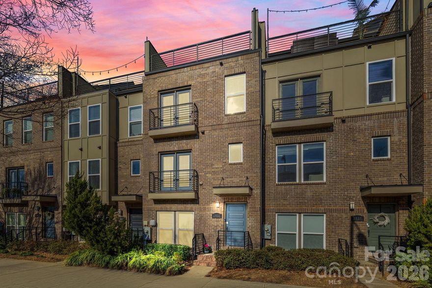 WELCOME HOME! This is the beautiful LoSo townhome in GATED South Village that you have been waiting for! Perfectly located steps away from the Scaleybark Light Rail Station, restaurants, breweries, and shopping; this light and airy townhome is move-in ready! Freshly painted throughout and ALL CARPET BRAND NEW! The open-concept light-filled main level features wood floors, a spacious great room, dining area and gleaming kitchen with quartz countertops, light grey cabinetry and stainless steel appliances. A deck with included grill and juliette balcony allow for seamless entertaining. Upstairs, you will find the large primary suite including huge closet and bath with double sinks and a spacious secondary bedroom with ensuite bath for maximum privacy. The third level includes an additional big bedroom that could be used as an office or workout room with an ensuite bathroom and sizable closet. From this bedroom, you step out on to your expansive roof top terrace, perfect for unwinding after a long day or to entertain guests. The 2-car tandem garage includes ample storage and an additional closet. Don't miss your chance to own this spectacular townhome in one of Charlotte's most sought after locations!