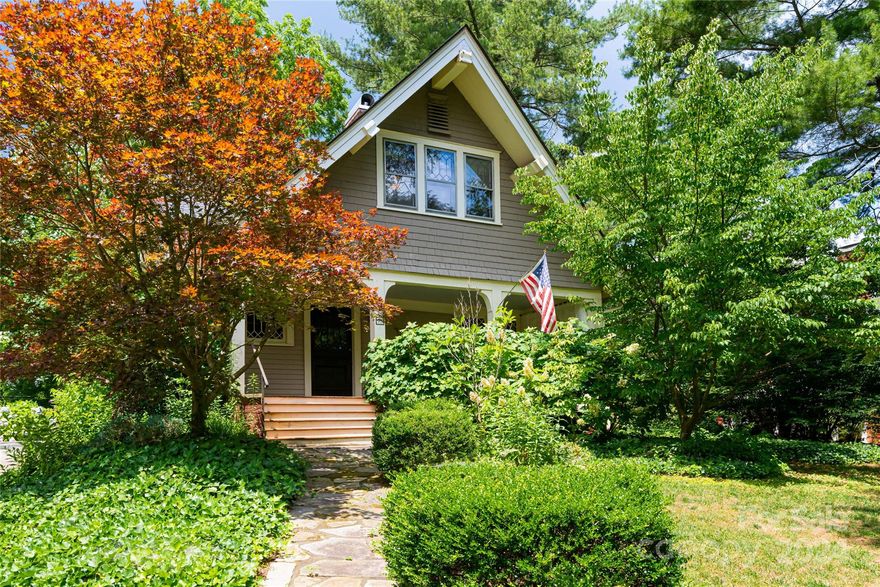 Discover the charm of Historic Montford in this immaculately maintained 1912 Arts and Crafts home nestled on a large lot with off street parking. Move-in ready, with original stain glass, hardwood floors, and windows with mullion details. Fully updated antique kitchen with Mission Style cabinetry, granite countertops, and walk-in pantry. Large rooms with natural light throughout. Formal Dining with Coffered Ceiling. Separate First Floor Laundry Room with storage. Beautifully updated bathrooms. Primary Bedroom Suite large enough for a King Size Bed including a walk-in closet, and large attached bathroom. Reading nook off the PBR with bonus enclosed storage space. Enjoy relaxing on the large covered front porch with views of Sunset Mountain. Take in sunsets on the screened-in porch or at the custom stone firepit and patio. All this is under updated forced central air and heat with fully updated electric panel. Bonus is a detached office/studio with hardwood floors and A/C.