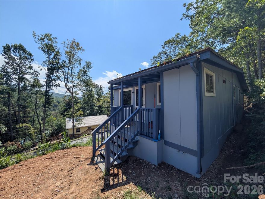 This could be your cabin in the mountains! This two bedroom one bathroom home has been recently painted on the exterior with updated flooring and bathroom fixtures. High ceilings in the living area with an open floor plan. Sit on the porch swing and enjoy the mountain air. Located in the peaceful McMillan Hidden Valley just 23 minutes from I-26 and shopping. New 2 bedroom septic tank and drainfield isntalled in August of 2025. ***Do Not Follow GPS to the home. It will get you to the neighborhood. Take the third Oak Ridge Rd access after you pass the home, not the first or second one. ***