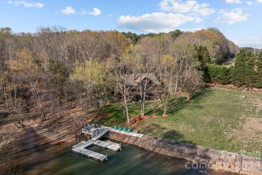 Welcome to 307 Stillwater Road, a quintessential Lake Norman retreat situated on a sprawling 1.28-acre lot where luxury and functionality live in perfect harmony. Located just moments from the natural beauty of Lake Norman State Park, this custom waterfront home is meticulously designed to showcase stunning panoramic vistas. Upon entry, the home’s warmth is immediate, highlighted by soaring A-frame windows, rich wood flooring, and a magnificent stone fireplace flanked by custom built-ins. The residence offers a rare and highly sought-after layout featuring two primary bedroom en-suites...one conveniently located on the main level and another on the walk-out lower level. This dual-primary design, paired with a stone fireplace on each floor, creates an ideal environment for multi-generational living, hosting long-term guests, or simply enjoying a private sanctuary on every level.

The seamless interior flow leads to an over-sized deck, an expansive outdoor sanctuary perfect for summer cookouts or peaceful morning reflections overlooking the water. For the hobbyist or lake enthusiast, the property includes a huge storage area with double access doors, providing the perfect space for water toys, workshop tools, or seasonal gear. Extra parking or storage available in the 20x24 outbuilding with bay door. A gentle path leads to your private, custom-built Lancaster dock complete with a boat lift. For those with four-legged friends, a small fenced side yard or a green thumb, the small fenced side yard provides a secure, manageable space without sacrificing any of your panoramic lake vistas. From the cozy fireside nights to the sun-drenched days on the boat, this property offers a rare opportunity to enjoy the very best of lakeside living on a significant piece of land.