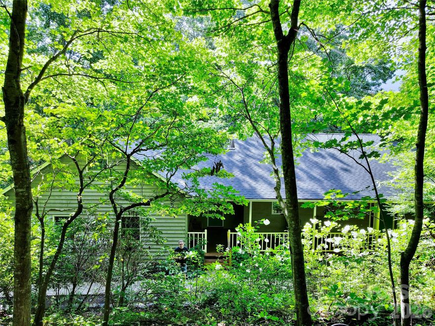 Private setting deep in a cool, shaded forest. This home offers serenity and privacy. Hike for miles right from your own front door. Community trail leads straight into the new Pisgah View State Park. AT&T fiber optic cable is currently being installed in the neighborhood. Great remote work location! Freshly painted with updates! New AC in 2024, whole house Generac generator with automatic on and off for comfort and reliability no matter what the weather brings. Added gas line for future fireplace in the main floor great room. Huge heated workshop in garage & added second electrical panel. New insulation. Covered porches and decks with cedar ceilings and ceiling fans. Views of Mt. Pisgah! Kayak rack holds 2 kayaks on the porch. Updated fixtures and lights. New refrigerator in kitchen along with Thermidor gas cooktop w/grill & griddle. Dacor conventional/convection oven and microwave. Custom built Maple cabinets. Built in office space and walk-in pantry. Bamboo floors throughout main level. Primary bedroom on main level, radiant floor heat in bath with spa tub and shower w/set point for water temperature. Downstairs family room, 2 bedrooms and updated full bath plus exercise room updated in 2023. Outside is a 2500 sf pet enclosure so your dogs can play even when you're busy. Gravel driveway with new gravel turnaround for easy parking. American Home Shield Platinum Home Warranty included.