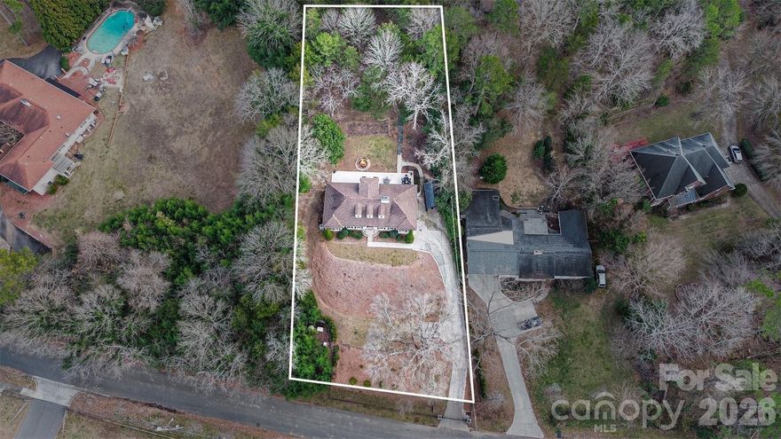 Tired of cookie cutter homes?  Look no further!  Presenting this rare privately gated retreat on nearly 1 acre with NO HOA! Offers complete privacy just minutes from SouthPark and Uptown Charlotte. Tucked behind a newly installed electric front gate with video keypad entry, this fully UPDATED and BEAUTIFULLY DECORATED HOME sits on a beautifully landscaped, fully fenced lot designed for both refined everyday living and exceptional outdoor enjoyment. The expansive backyard offers true seclusion and is thoughtfully designed to accommodate a future in-ground pool, garden retreat, or additional outdoor living features with endless possibilities. A brand-new 60’ x 14’ patio and custom fire pit create the perfect setting for entertaining or quiet evenings surrounded by nature.          

Inside, the light-filled main level features hardwood floors throughout much of the home and stunning floor-to-ceiling windows that frame serene backyard views. Multiple living areas provide effortless flow for entertaining, while the gourmet kitchen serves as the heart of the home with granite countertops, stainless steel appliances, and abundant custom cabinetry. The primary suite offers a private retreat with two walk-in closets, en-suite bath and sliders to the backyard, complemented by two additional well-appointed bedrooms on the main level. Upstairs, a massive walk-in attic presents outstanding potential for future expansion, along with a private 12’ x 6’ balcony overlooking the backyard making it an ideal spot to enjoy morning coffee and local wildlife.          

The fully finished lower level adds remarkable flexibility, featuring a spacious living space great for many uses, a private bedroom and full bath, and a separate flex space ideal for a home office, media room, or bar. A private exterior entrance with access to the side driveway provides an ideal setup for guests, in-laws, or multigenerational living. The attached two-car garage includes a dedicated workshop or hobby space that is both heated and air conditioned, offering both function and versatility.                           

Additional highlights include upgraded electrical systems with whole-home GFI protection and a premier location close to Charlotte’s top private schools, places of worship, the McAlpine Creek Greenway, and the prestigious shopping and dining of SouthPark.          

An exceptional opportunity to own a private, acreage estate without compromise, combining space, privacy, and convenience in one of South Charlotte’s most desirable locations.