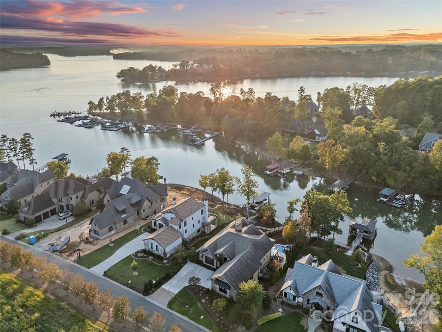 Luxury, sunset view Lake Wylie waterfront living at its FINEST! This custom built, 2 story home features high end finishes throughout, resort style pool & spa, plus a private dock located in a quiet cove with immediate access to the lake & is located in the beautiful, gated community, Reflection Pointe. The home features 5 bedrooms, 4 full bathrooms, 1 half bathroom, 4,704 heated square feet & 2,689 unheated square feet, incredible indoor/outdoor living with sliding doors to the main level porch & lower level screened in patio, outdoor fire pit & fenced in backyard with beautiful landscaping. Main level features incredible lake living with sunset views, 2 bedrooms, 2 full bathrooms & 1 half bathroom. Stunning chef's kitchen has cherry & maple cabinets, granite countertops, oversized island with seating, dual built-in stainless steel Frigidaire refrigerator & freezer, stainless steel appliances, prep sink in kitchen island with disposal, large butlers pantry with additional sink & dishwasher, & bar with ice maker. Kitchen overlooks the light filled, vaulted living room with a French marble fireplace & sliding door access to the deck. Primary suite has stunning lake views, gas fireplace, sitting area/office, double vanity, shower, bathtub, water closet & walk-in closet with access to the laundry room. Secondary bedrooms are spacious & private. Two car garage has epoxy floors, separate workshop, sink & large drop zone when you enter the home. Lower level features an oversized family room with gas fireplace, 3 bedrooms, 2 full bathrooms, incredible walk in storage & sliding door access to the screened in porch. Additional features include 10 foot ceilings on main & lower levels & 22 foot ceilings in the foyer, dining & living rooms, mahogany wood floors on main level, 3 gas fireplaces throughout, full brick & stone exterior, newly updated & refinished pool system to include new plaster, all new pumps & blowers, Hayward 440,000 BTU pool & spa heater & much more (see attached features list). Neighborhood amenities include gated community, Lake Wylie waterfront, clubhouse, lagoon swimming pool, lighted tennis & pickleball courts, walking paths, beach area on Lake Wylie, playground, boat storage, boat slips, boat launch canoe, kayak dock & storage & pavilion. Just minutes away by boat of Morningstar Marina, Papa Doc's, Lake Wylie Marina & Drift, & within close proximity to the finest shopping, dining & activities to include the CLT airport, Daniel Stowe Botanical Gardens, US National Whitewater Center, Rivergate Shopping Center, Lake Wylie Shopping, Berewick Town Center, Charlotte Premium Outlets, Tega Cay Shopping Center & more. A must see home!