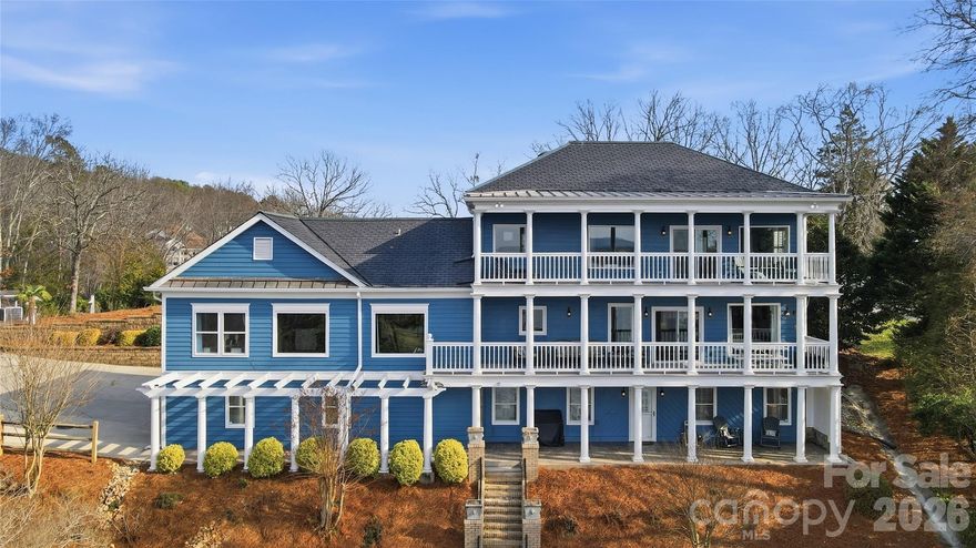 This one-of-a-kind Charleston-inspired waterfront estate is perfectly positioned along the shores of Lake Wylie, tucked at the end of a quiet private drive shared by only 3 other homes and no HOA. Offering approximately 4,187 SQ FT across 3 thoughtfully designed levels, every floor features its own covered porch or patio with sweeping, year-round lake views. The home's layout is exceptionally well-suited for multi-generational living or entertaining on a grand scale.  The lake-facing Great Room showcases breathtaking water views and opens to the dining area and kitchen. Renovated gourmet kitchen is beautifully appointed with Cambria quartz countertops, GE Profile appliances, a 5-burner cooktop, wall oven, custom hood, tile backsplash, and under-cabinet lighting. A formal dining room with classic wainscoting adds timeless charm. A spacious second primary suite on the main level (currently used as 2nd home office) features a walk-in closet, 2 additional storage closets, a cedar-lined closet, and a full bath.  Dedicated home office boasts incredible lake views, making it ideal for remote work. The guest and theater wing also includes a new electric fireplace, new full-size windows with a stunning lake view, a wired 7.1 home theater system with built-in speakers, and two built-in refrigerators - one for beverages and one for wine.  The 2nd floor is devoted to the primary suite with a cedar-lined walk-in closet, dressing area, oversized laundry room, spa like bath with heated floors, and a large private porch with unobstructed lake views. The lower level includes two bedrooms, each with its own en-suite bath (one full, one half), plus a comfortable sitting area and 2nd laundry. Designed for those who love to entertain and embrace lake life, enjoy boating, fishing, and swimming from your private dock with boat and jet ski lift, or relax on the covered dock sitting area.  Soak in the sun and peaceful surroundings on the private sandy lounge area.  Additional highlights include an oversized 3+ car garage with a dedicated workshop, wired for RV connection, abundant storage, parking for multiple vehicles, a simulated slate 50+ year roof, exquisite architectural details throughout, beautiful flooring, plantation shutters, and magnificent lake views. Great Palisades area location convenient to shopping, dining, and The Palisades Country Club.  Thoughtfully renovated and cared for, this exceptional waterfront retreat is luxury lake living at its finest.
