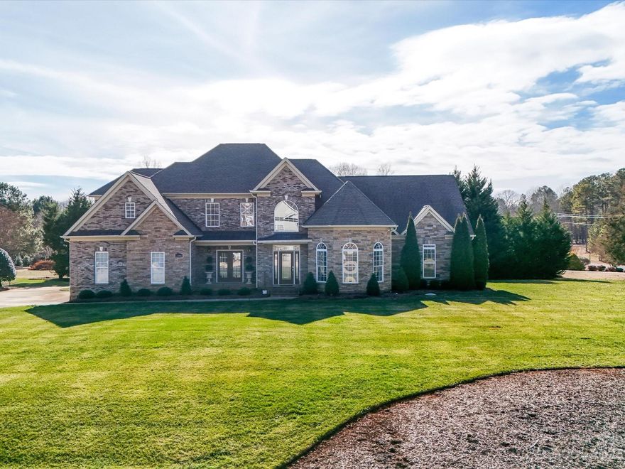 NEW ROOF HAS BEEN INSTALLED. Stately home on over an acre manicured lot. Grand foyer w/dbl trey ceiling. Exquisite heavy moldings & chair rail thru out the home. Hdwds & 18" tile on both levels. High-end fixtures & ceiling fans. Office/study w/dbl trey & bay window. Formal DR leads to covered porch. Kit w/white cabs, island, granite, tile backsplash, gas range w/decorative hood, ss appls & bay window. Huge Primary bedrm on main has trey ceiling & grand bathrm, dbl bowl vanity w/custom designed walk-in closet & walk-in shower.  Large flex space has a sunrm, closet & additional bathrm.  Nice 2ndary bedrms & bonus room up. Bathrms have granite counters & bath access to every room. Wood stairs w/wrought iron railings & lights. Laundry rm has sink, cabs & desk area. Huge walk-in attic. Garage has xtra space, cabs & countertops. Large trex deck. Both units up & down were replaced in summer of 2023. Whole house generator. Encapsulated crawl space. ASSUMABLE VA LOAN AT 2.5% INTEREST RATE.