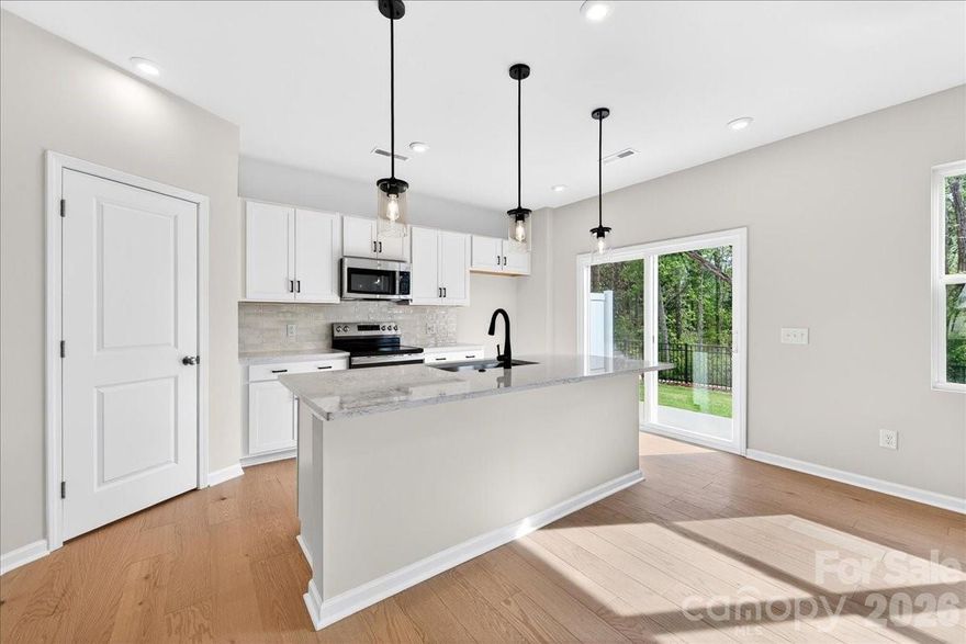 Welcome home to 6053 Longar Lane, a stunning 2-bedroom, 2.5-bath, two-story Anson Plan in Fifteen 15 Cannon featuring the Welcoming II Design Package with crisp white cabinetry throughout, sleek black hardware, and a chef-inspired kitchen showcasing white quartz countertops, white 3x12 Mesmerist Spirit backsplash, a large single-bowl island sink, and a generously sized walk-in pantry. Step directly from the kitchen onto your extended outdoor living space, which backs to a wooded area with no direct rear neighbors, perfect for relaxing or entertaining. High ceilings and abundant natural light fill the home, while a flexible loft offers the ideal space for a home office or additional living area. The primary bathroom impresses with a fully tiled shower with tiled floor pan and a dual vanity, and an upstairs laundry closet adds everyday convenience. Located in Fifteen 15 Cannon with easy access to I-85, commutes to Charlotte, Concord, and surrounding areas are effortless and with NoDa, Camp North End, and Uptown Charlotte just minutes away, you're always close to the best dining, entertainment, and culture the city has to offer.