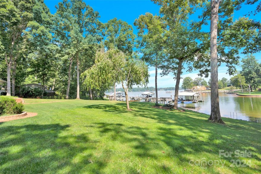 Everything you could want in a waterfront home! Near flat lot with far ranging views tucked slightly off main channel. Extra-large dock suitable for entertaining in quiet, heavily treed older neighborhood. This charming brick home has been perfectly maintained. Circular drive, oversized 2 car heated garage. Wrap around deep porch maximizes the views. Open floor plan features great room with masonry fireplace, island bar with sink, and French doors opening onto the huge lakeside porch. Primary suite on main level with luxury bath and 2 separate closets. Upstairs has 2 bedrooms, both with skylights and shared bath. Lower level walk-out basement is finished and inviting with wet bar and beverage fridge. Lower rec room has a fireplace, built-ins and French doors leading to additional seating area. While not permitted there is a charming detached brick building currently being used as garage, workshop (it has power); wired for emergency generator. Oversized permitted pier and covered slip.