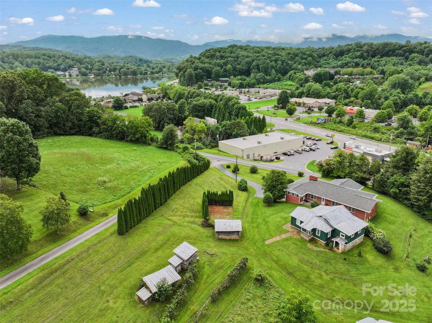 Exceptional 2.58-acre property with 350+ feet of road frontage, offering prime visibility, long range views. This pristine, level-to-rolling pasture is "not zoned" allowing residential, commercial, multipurpose use and is located just 100 yards from highest county traffic count 5-lane intersection, behind Dunkin’ Donuts and Dollar General. The 2,200+ sqft brick ranch features a 10x20 covered front porch, 3 BR/3 bath, abundant natural light, large living/dining rm. An 1,800+ sqft unfin basement. Adding historic charm, a 103-year-old cabin & barn await restoration. Public water/sewer ideal for a private estate, commercial development, or mixed-use project.