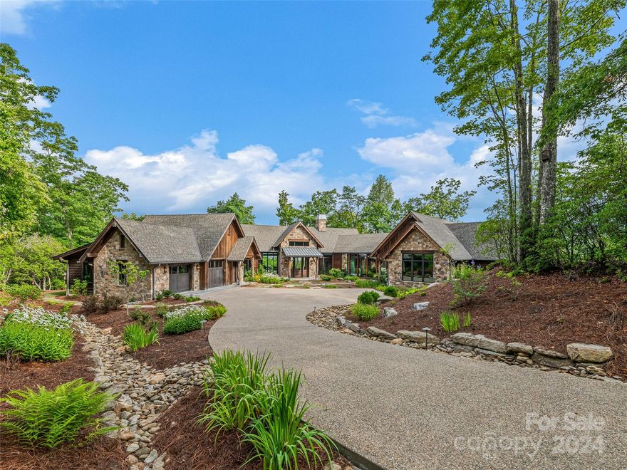This stunning custom home in Pisgah Forest, NC, masterfully designed and built by Platt Architecture and Builders of Brevard, offers luxurious mountain living at its finest. Positioned on a gentle ridge with unparalleled long-range views of Pisgah National Forest, the single-level residence provides peace of mind with its private well, whole-house generator, and geothermal underfloor heating. Step inside to discover reclaimed wood floors and ceilings, soaring cathedral ceilings with exposed wood beams, and nickel board walls that add rustic elegance. The home features a state-of-the-art theater, a well-equipped gym, and two spacious garages. The large screened porch is perfect for entertaining, with its stone fireplace, BBQ station, and flagstone floors. A whole-home system allows you to control lights, security, and shades at your fingertips. Enjoy over six miles of private hiking trails located on the 200 acres of conservation easements and connecting to the Dupont Forest.