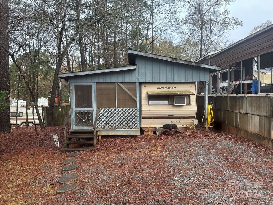 This 2 bedroom, 1 bath unit has fresh updates and is ready for you to come for the summer.  Nice size lot with plenty of parking.  The camper has fresh paint, flooring, new LED lights, new shower, real potty and vanity.  Each room has a barn door for privacy. Furniture to remain (except Grandmas rocking chairs on porch). There is a kitchenette on the porch with refrigerator, sink and microwave. Great storage throughout. Come and see if this is your happy place.  Clients must be with an agent to access the community.