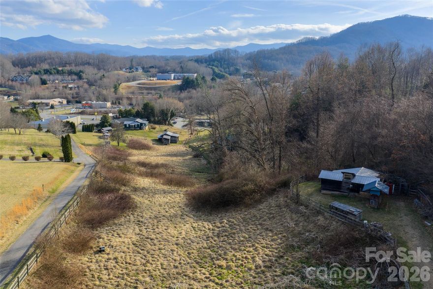 Discover this exceptional opportunity to own +/- 2.24 acres of unrestricted, rolling pasture land in the heart of Western North Carolina’s stunning mountain landscape. Nestled just 5 minutes from the vibrant downtown Waynesville this vacant parcel offers the perfect blend of seclusion and convenience.  This includes strolling from your future homesite to the serene grounds of Lake Junaluska, where you can enjoy walking trails, scenic lakeside views, and community events year-round. Boasting paved road access for easy entry, the property features breathtaking long-range mountain vistas that captivate in every season, from the fiery hues of autumn to the crisp whites of winter. Previously utilized as a mini farm the land comes equipped with existing fencing and a practical equipment shed, and barn providing a solid foundation for agricultural pursuits or seamless transition to residential development. Its gentle topography and unrestricted zoning open endless possibilities—envision crafting your private estate, or development potential, this parcel is primed for your vision. Whether you’re seeking a peaceful retreat amid nature’s splendor or an investment with versatile appeal, this easily developable property promises unparalleled potential in one of the region’s most desirable locations.